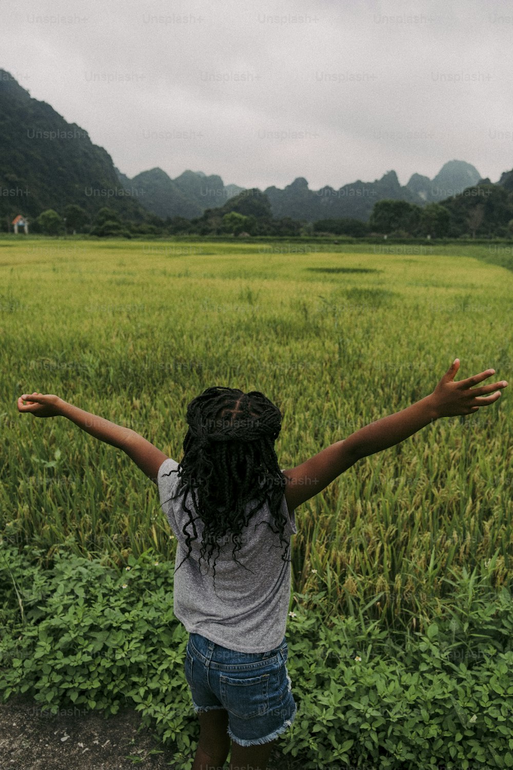 a woman standing in a field with her arms outstretched