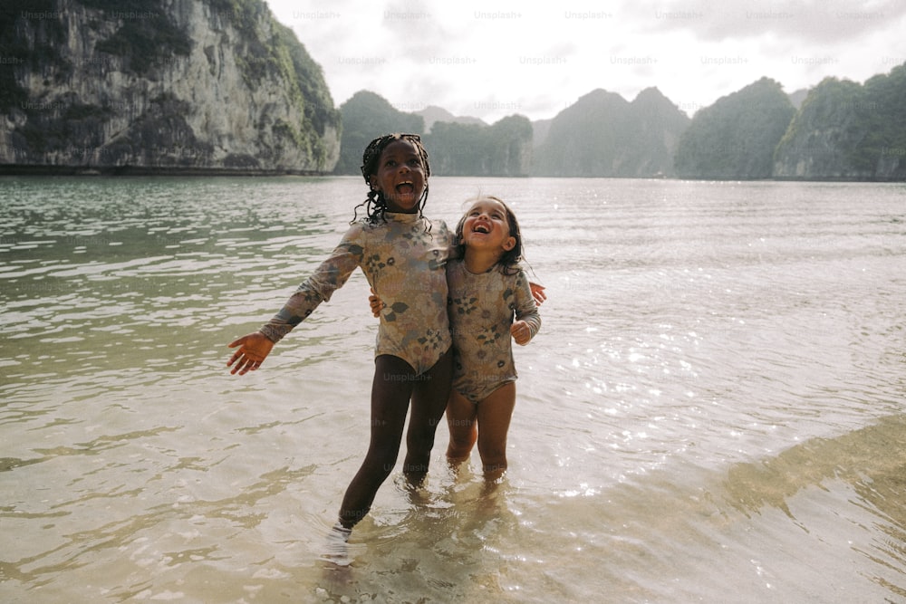잠수복을 입은 두 어린 소녀가 물에서 놀고 있다