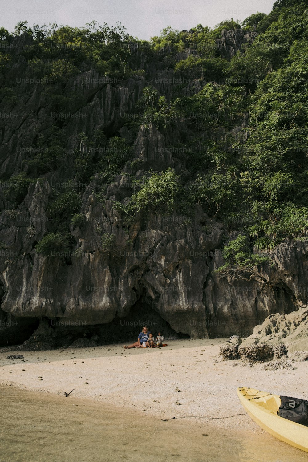 un paio di persone sedute sulla cima di una spiaggia sabbiosa