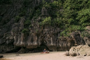 a group of people sitting on top of a sandy beach