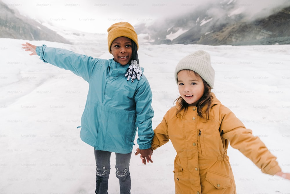 a woman and a little girl standing in the snow