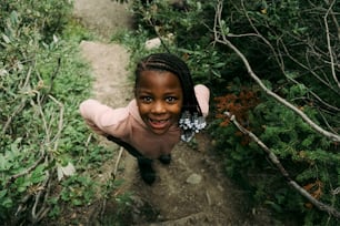 Una bambina in piedi nel mezzo di una foresta