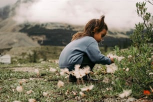 Eine Frau, die in einem Blumenfeld kniet