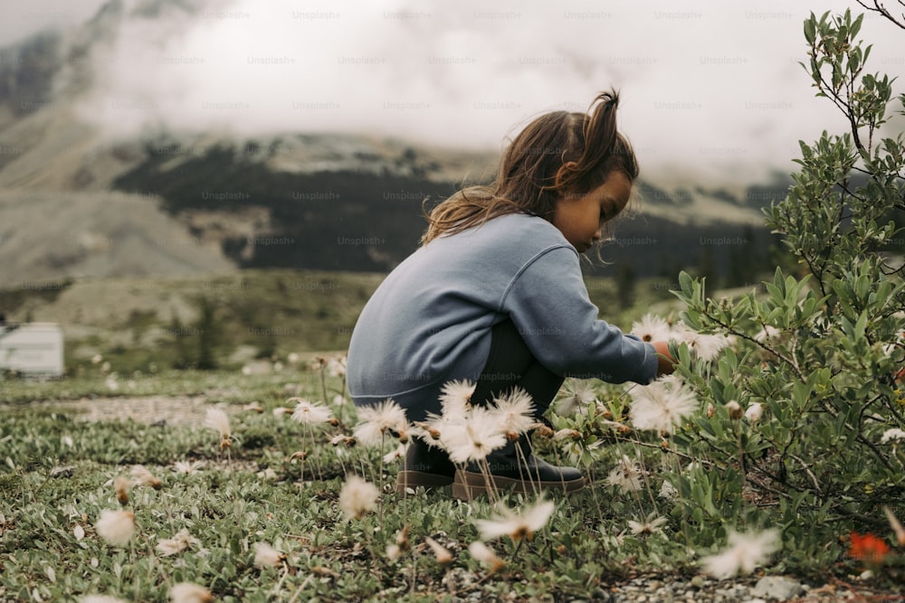 Une femme agenouillée dans un champ de fleurs