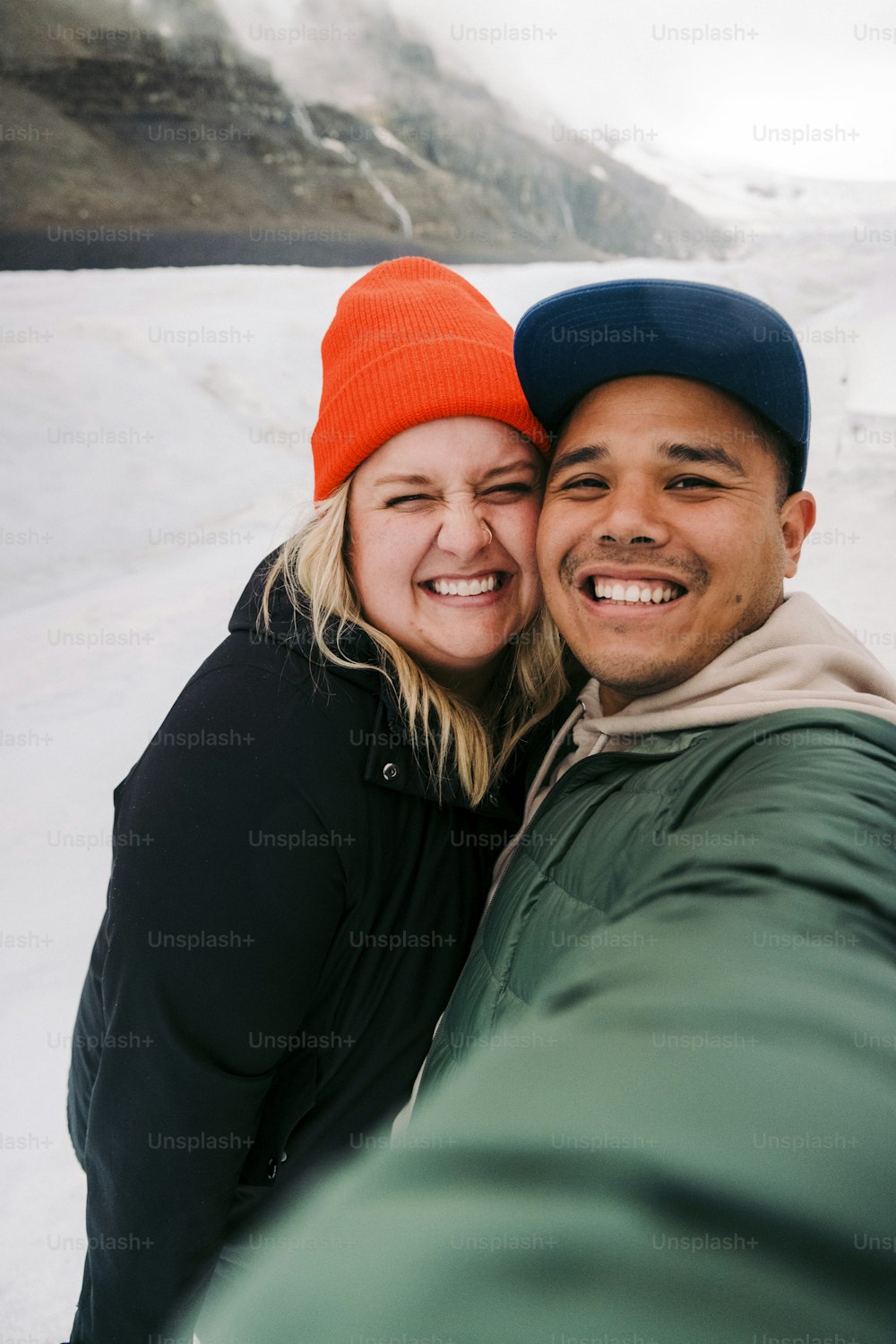 um homem e uma mulher tirando uma selfie na neve