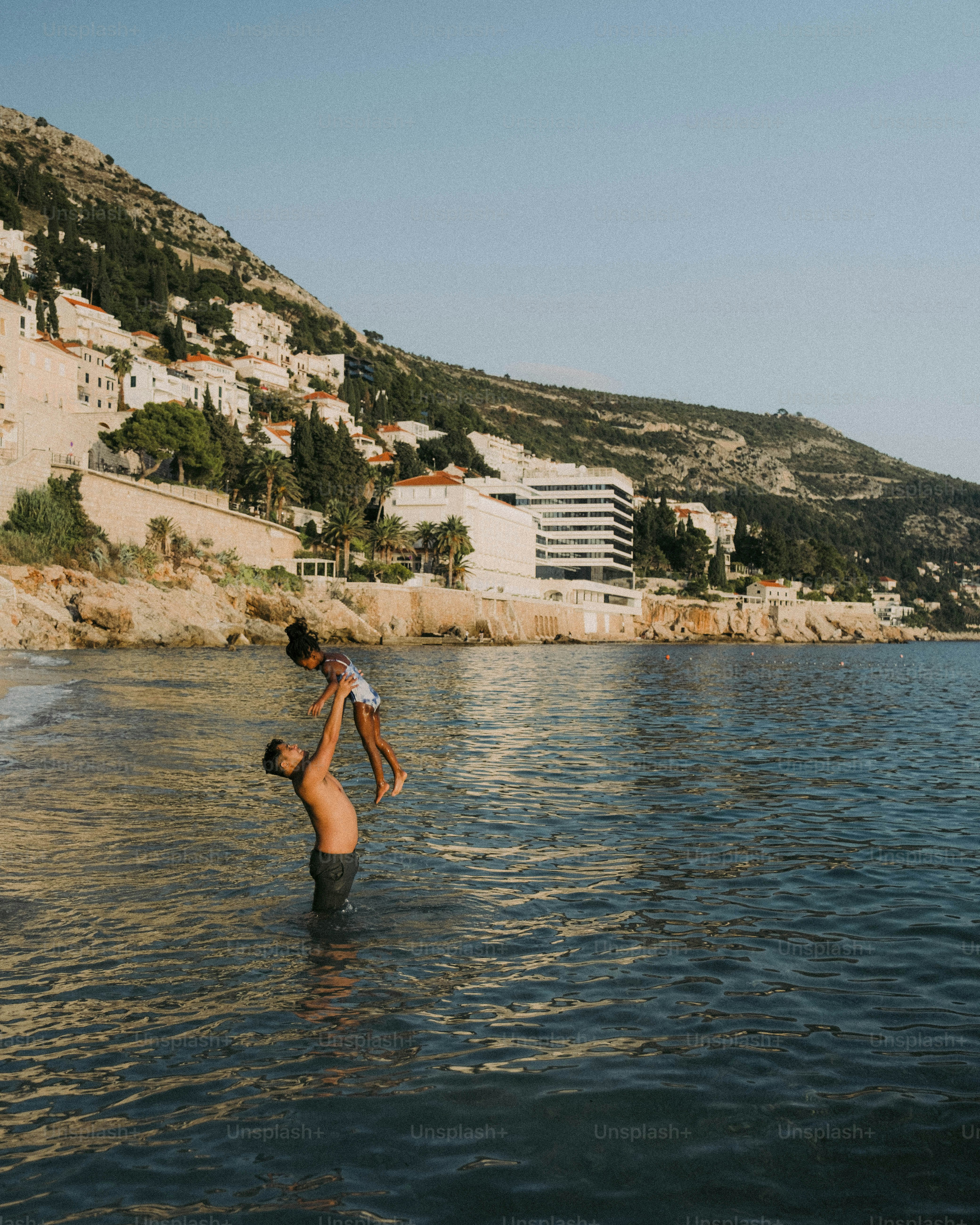 a man holding a child in a body of water