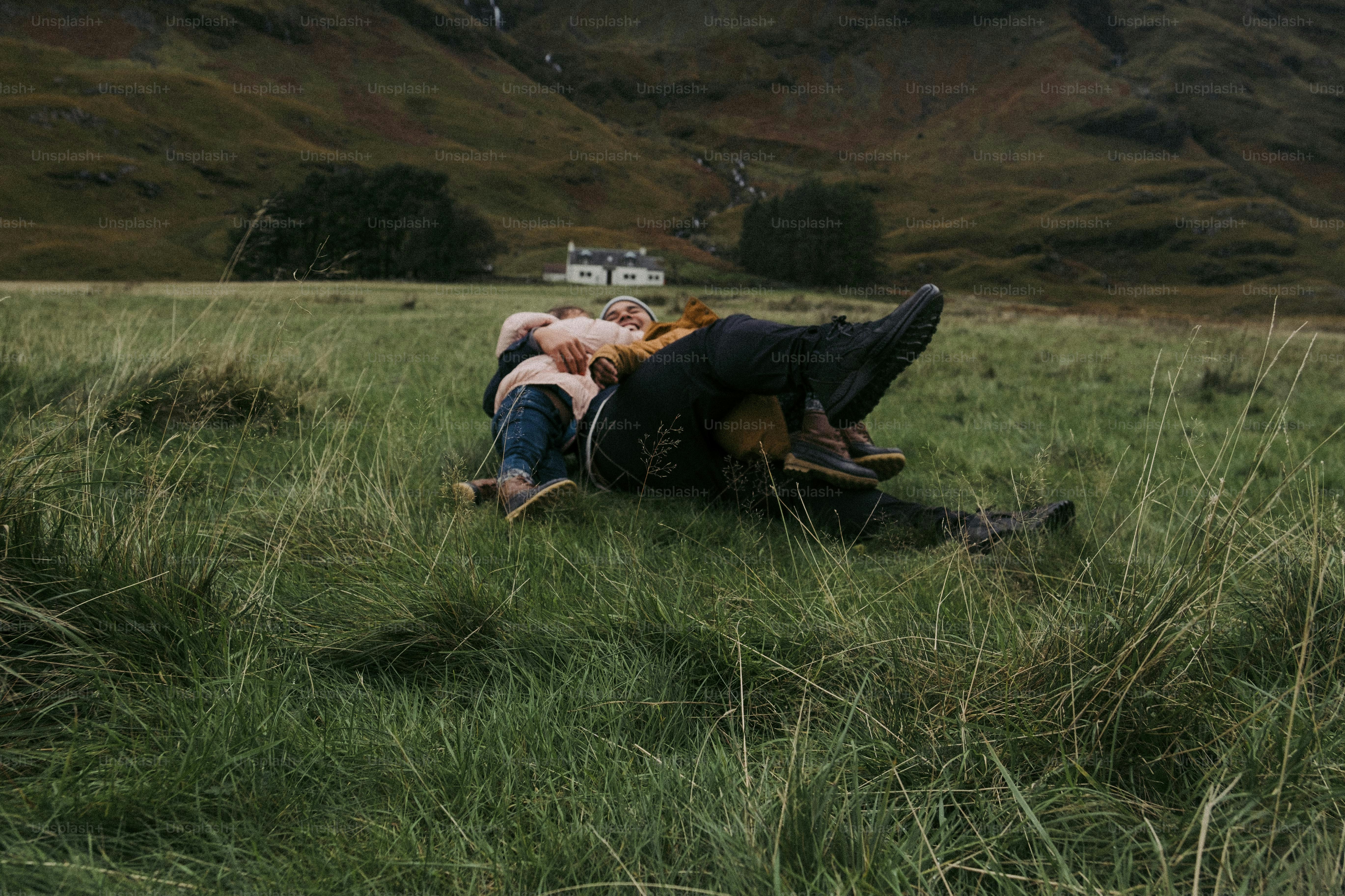 un homme et une femme allongés dans l’herbe