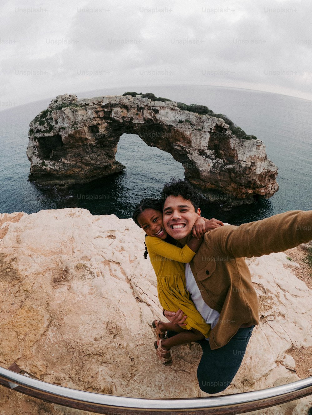 um homem e uma mulher tirando uma selfie no topo de um penhasco