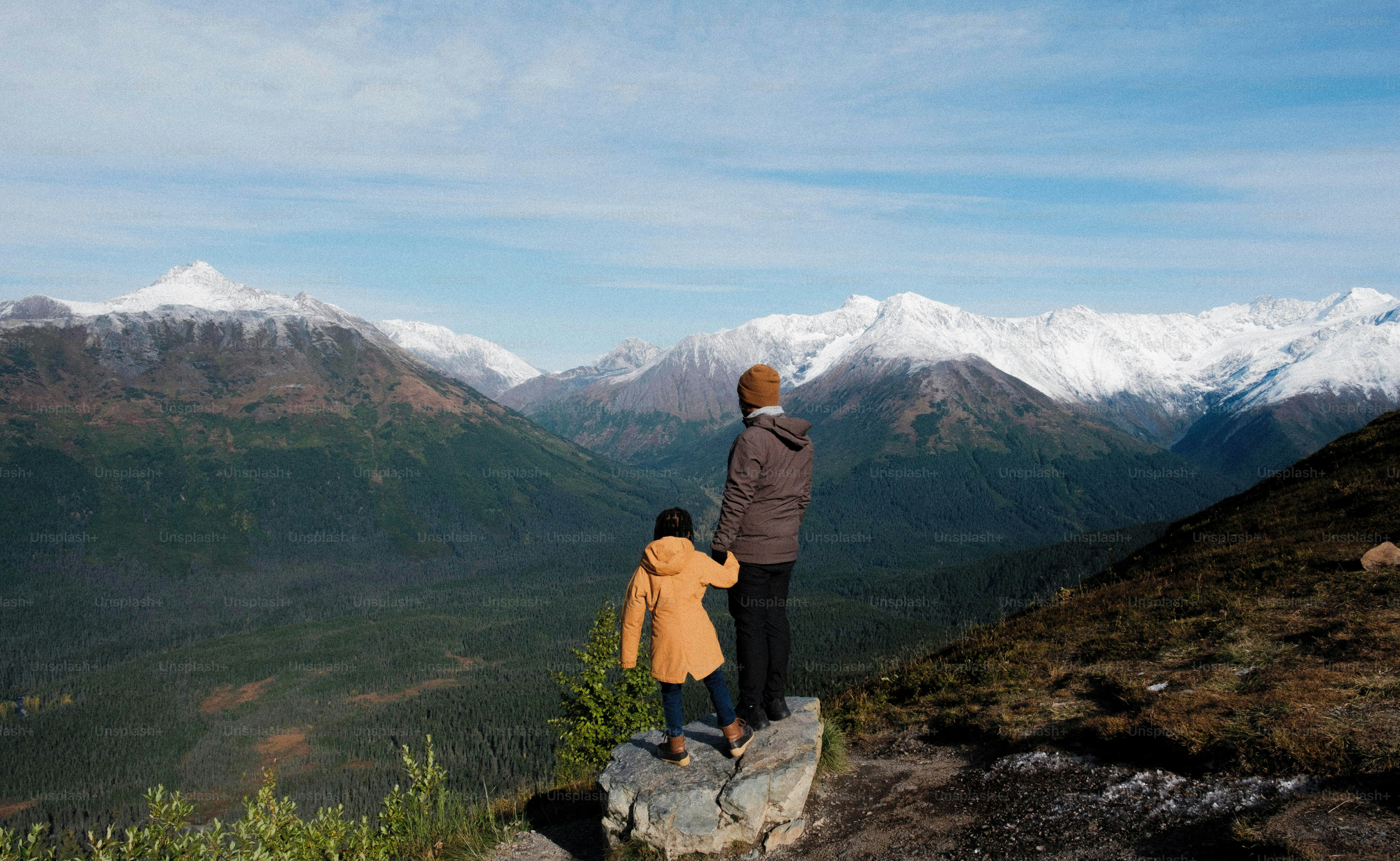 a couple of people standing on top of a mountain