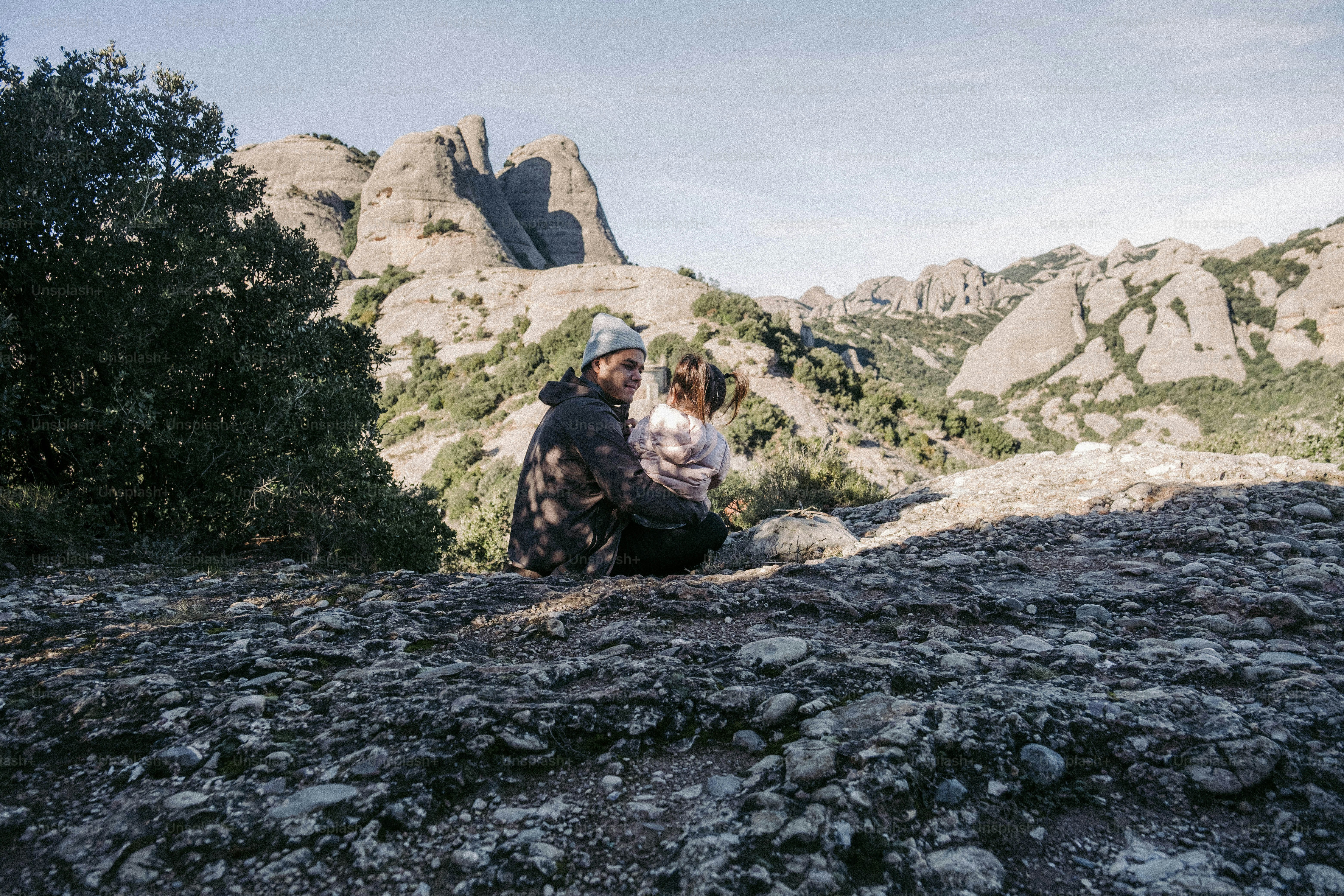 a couple of people sitting on top of a mountain