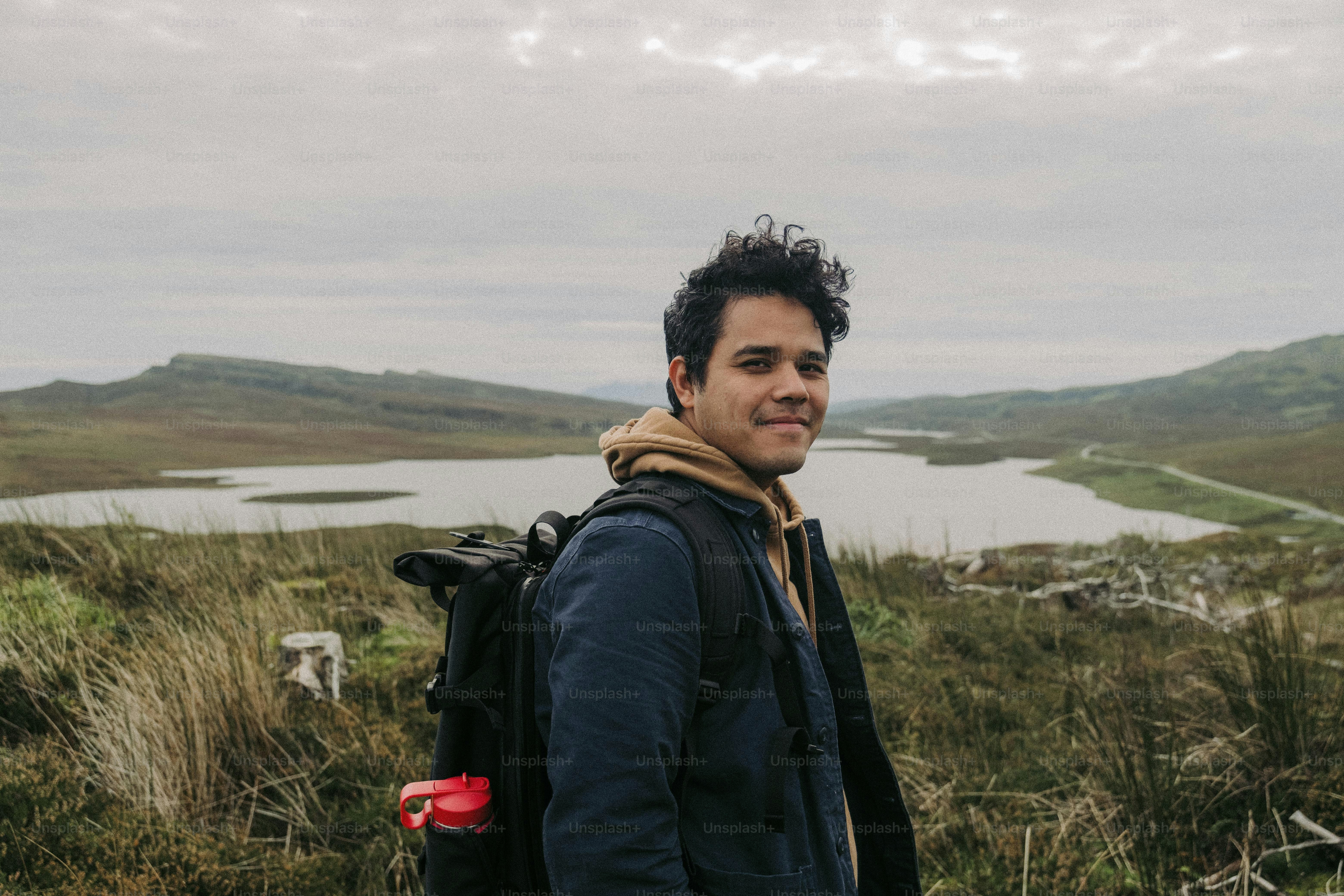 Un homme avec un sac à dos debout dans un champ