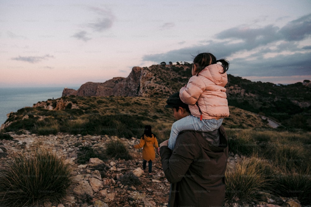 uma mulher carregando uma criança até uma colina