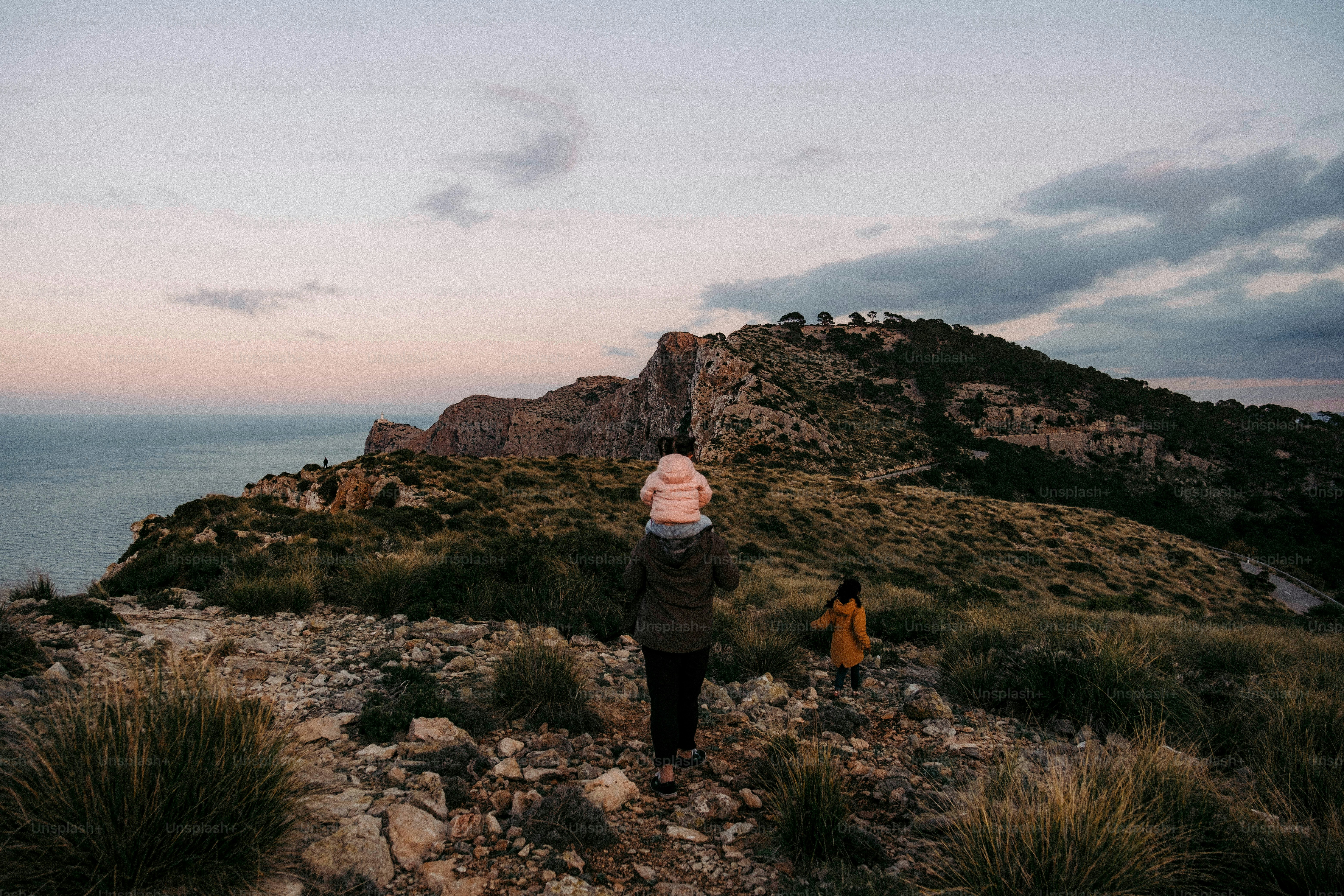 Deux personnes marchant sur une colline avec vue sur l’océan