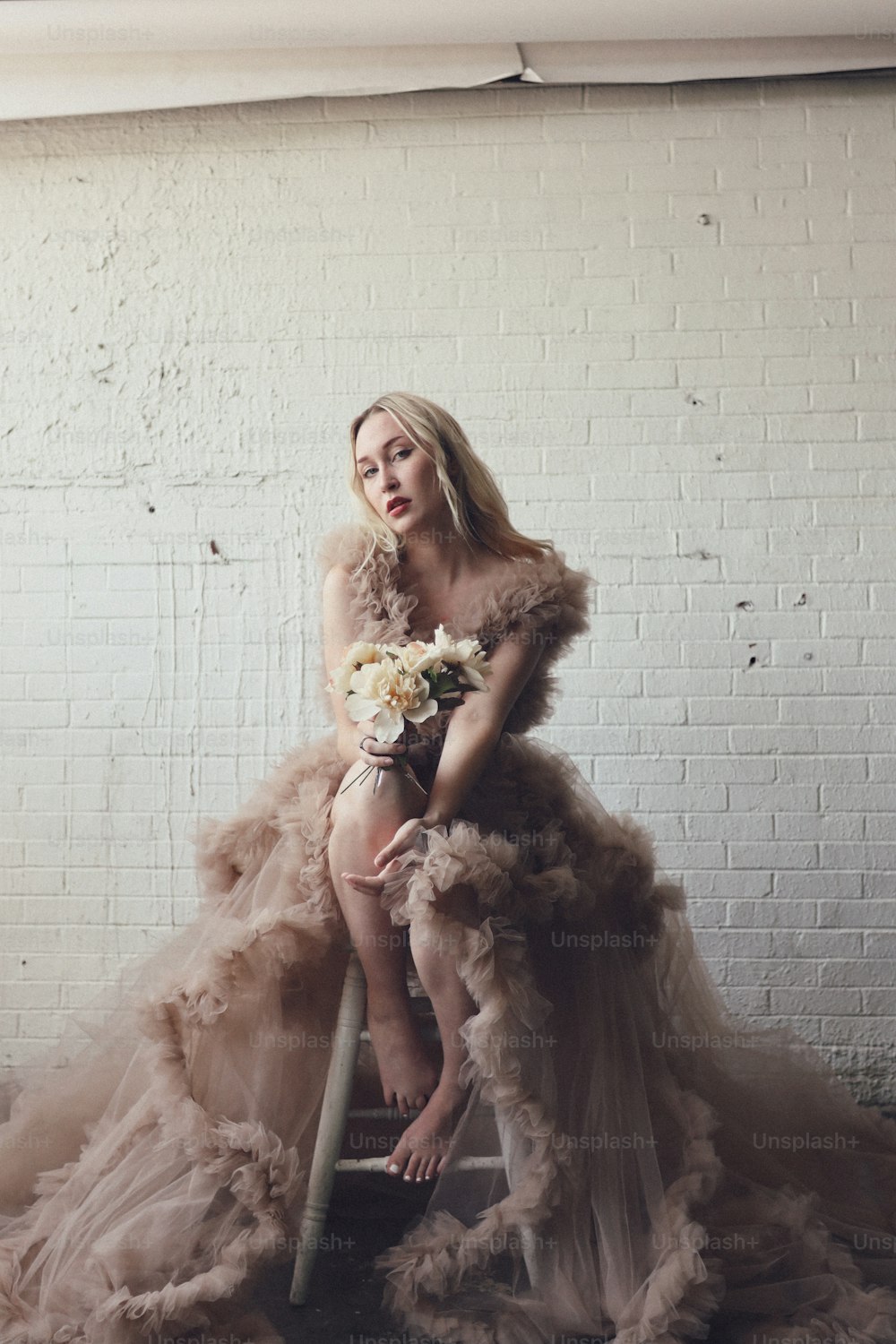 a woman sitting on a chair with a bouquet of flowers