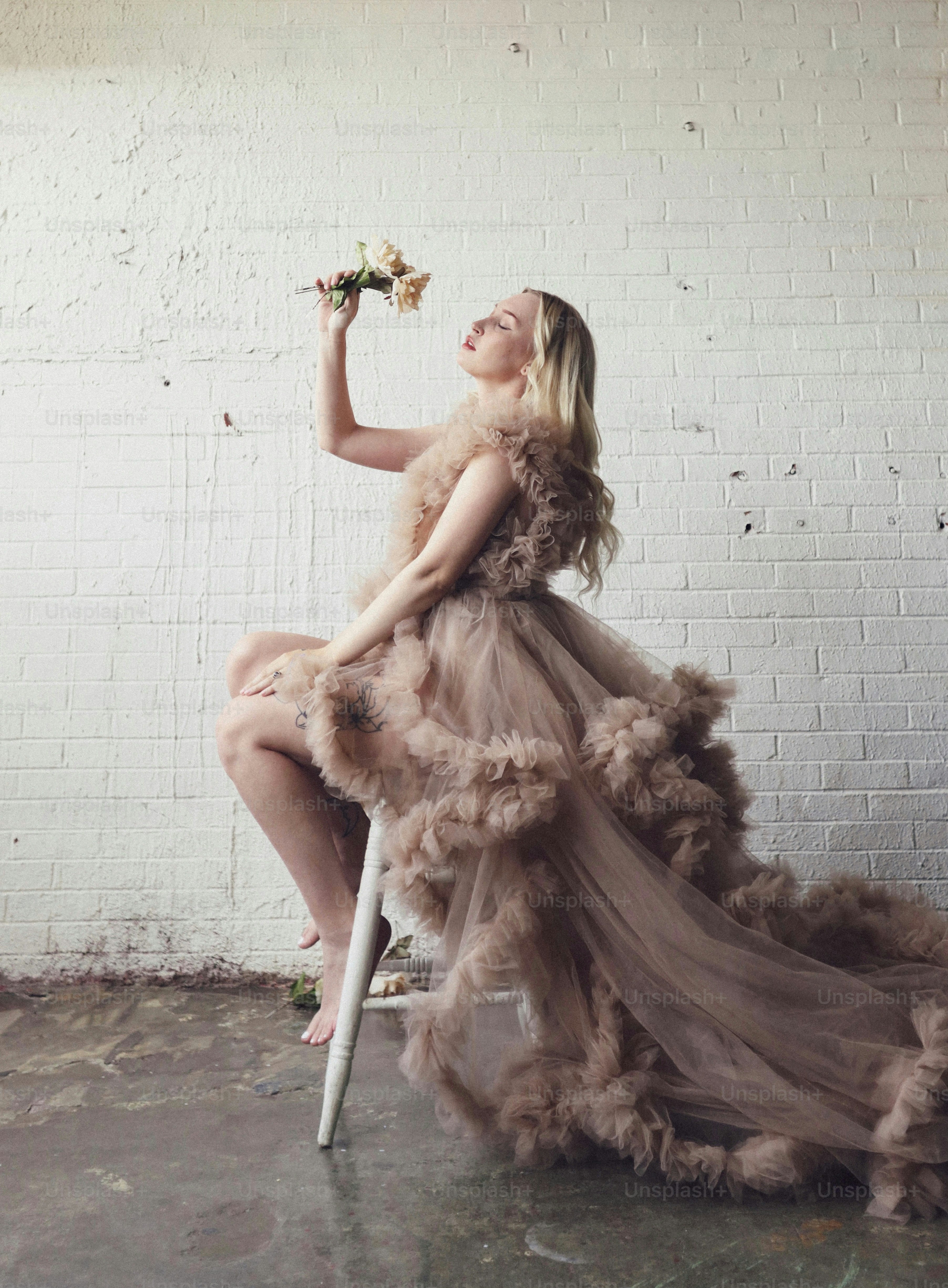 uma mulher sentada em uma cadeira segurando uma flor