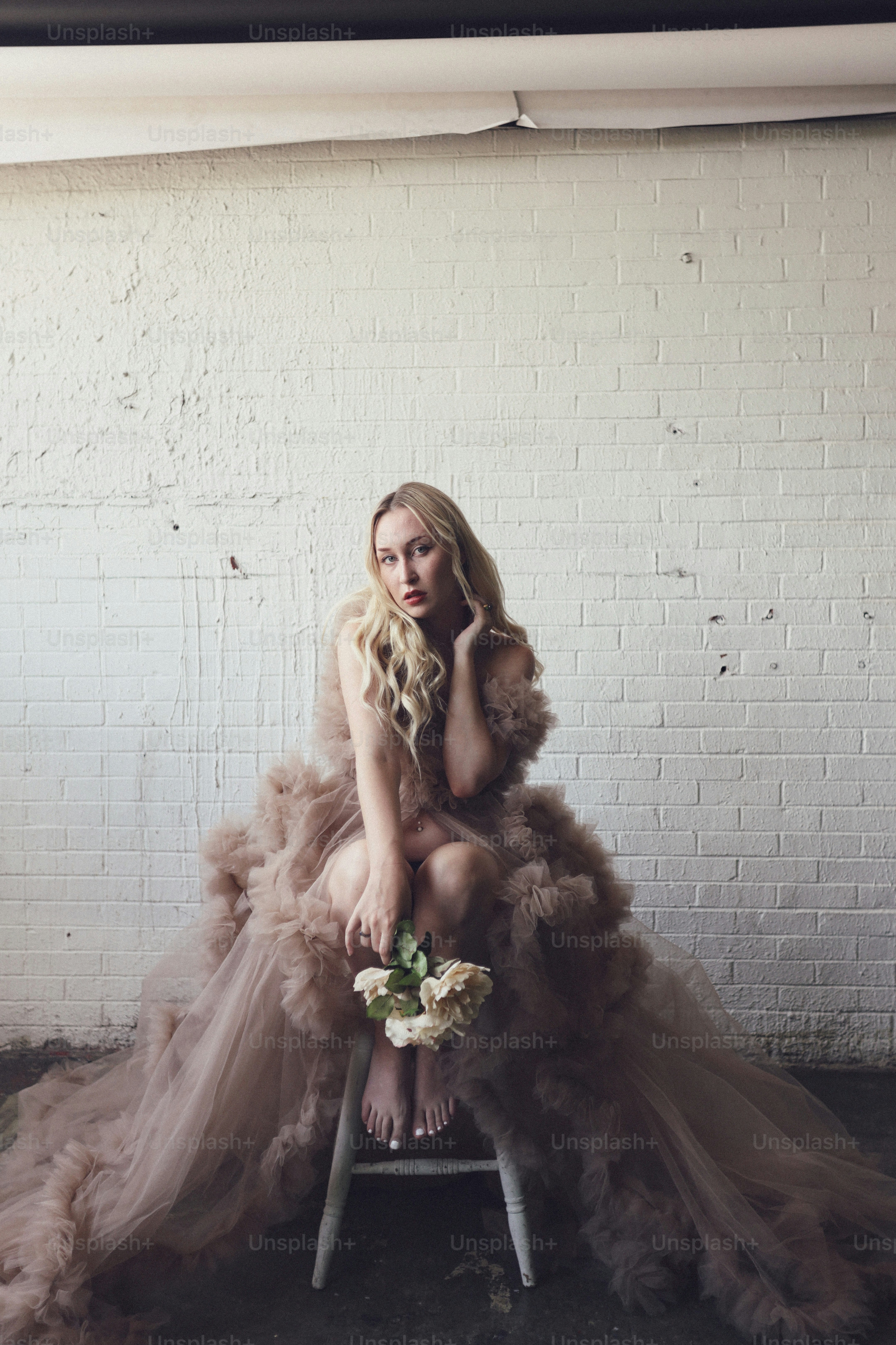 a woman sitting on a stool in a dress