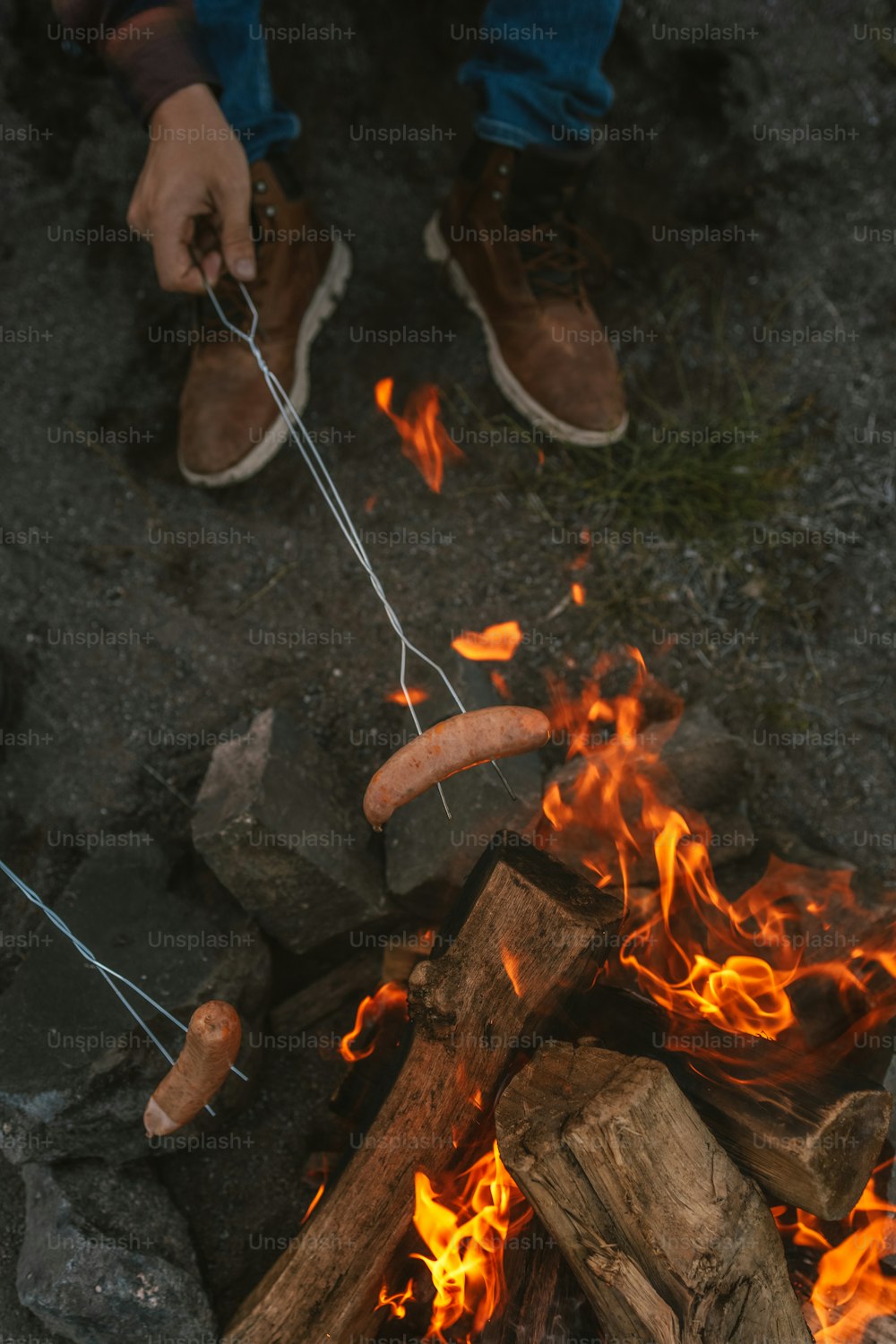 Ein Hot Dog wird über einem Lagerfeuer gekocht