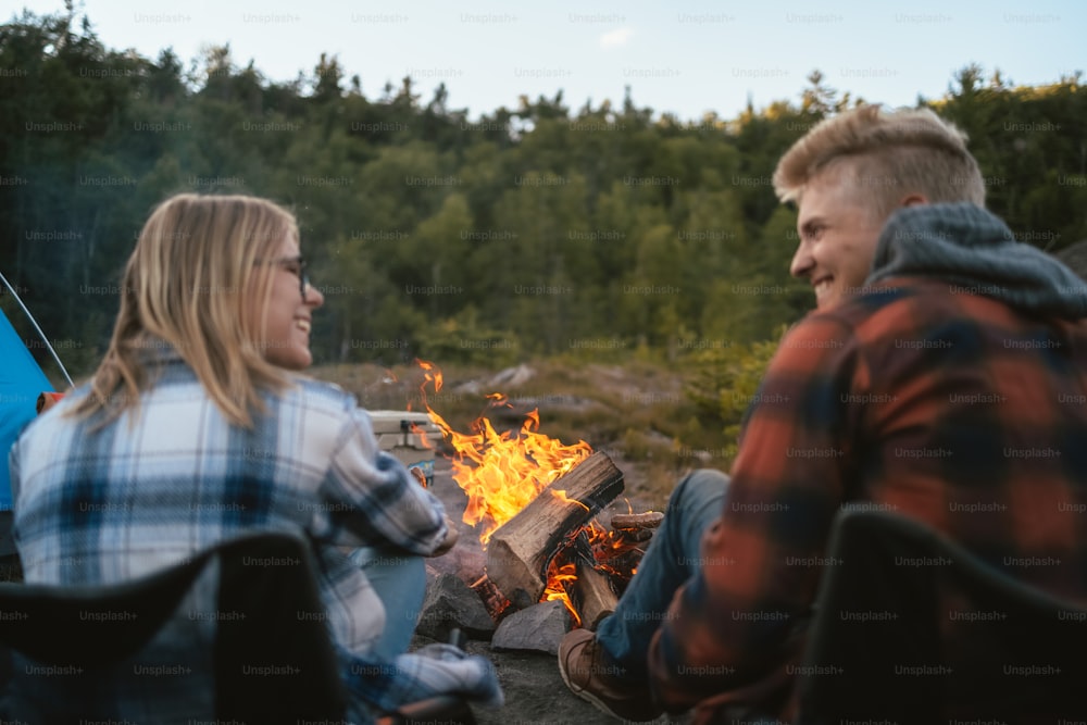Ein Mann und eine Frau sitzen am Lagerfeuer