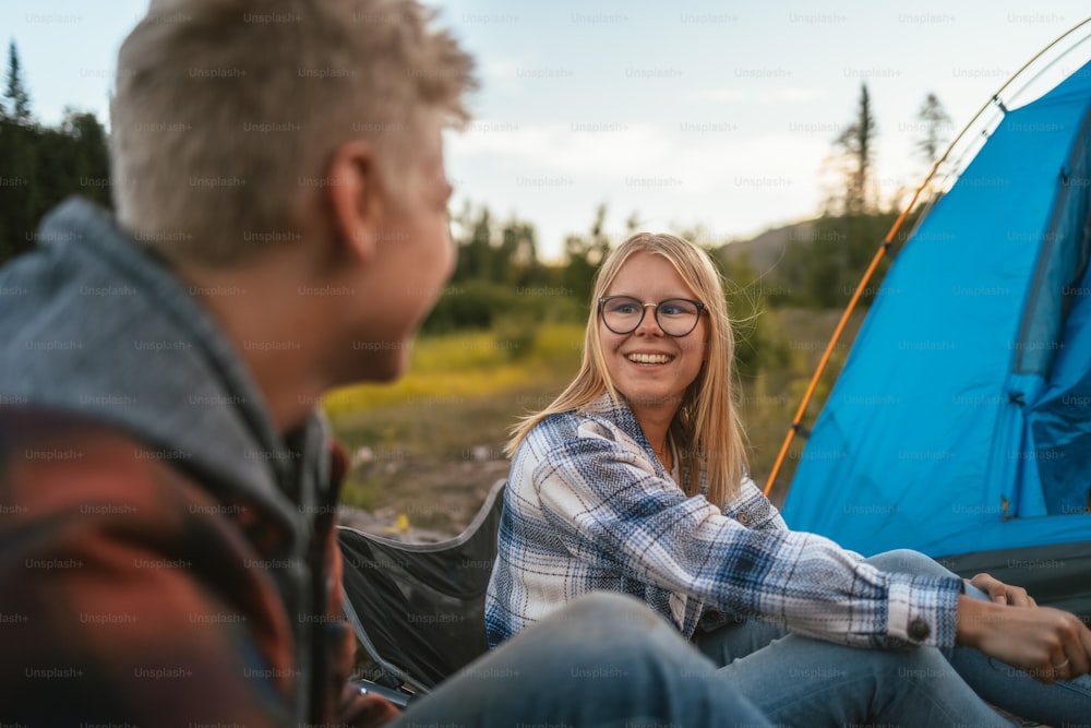 Ein Mann und eine Frau sitzen neben einem Zelt