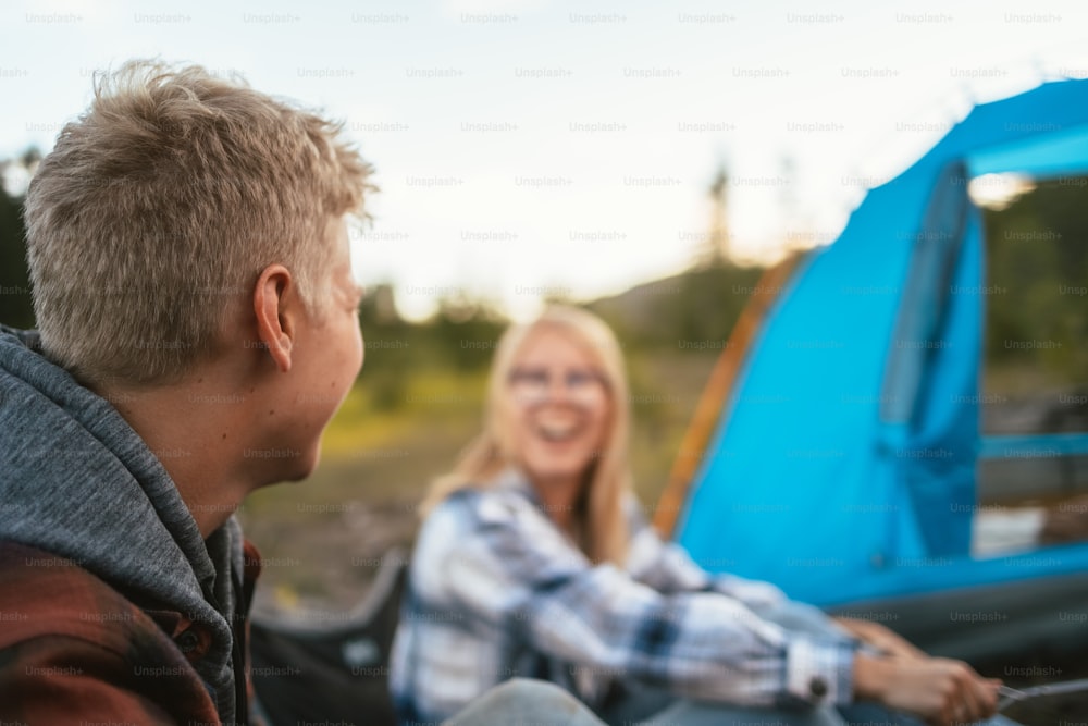 Un uomo e una donna seduti accanto a una tenda blu