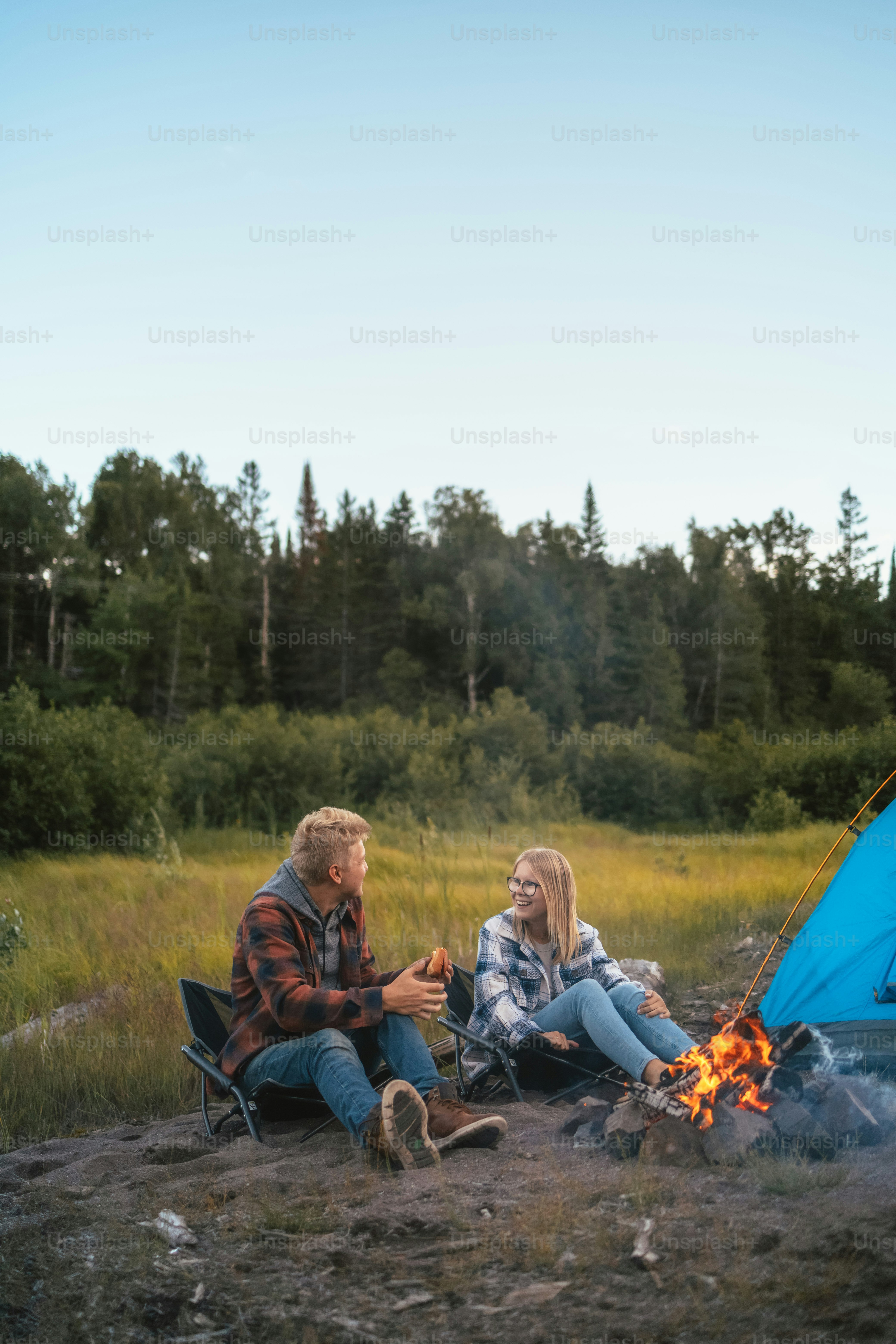 Ein Mann und eine Frau sitzen am Lagerfeuer