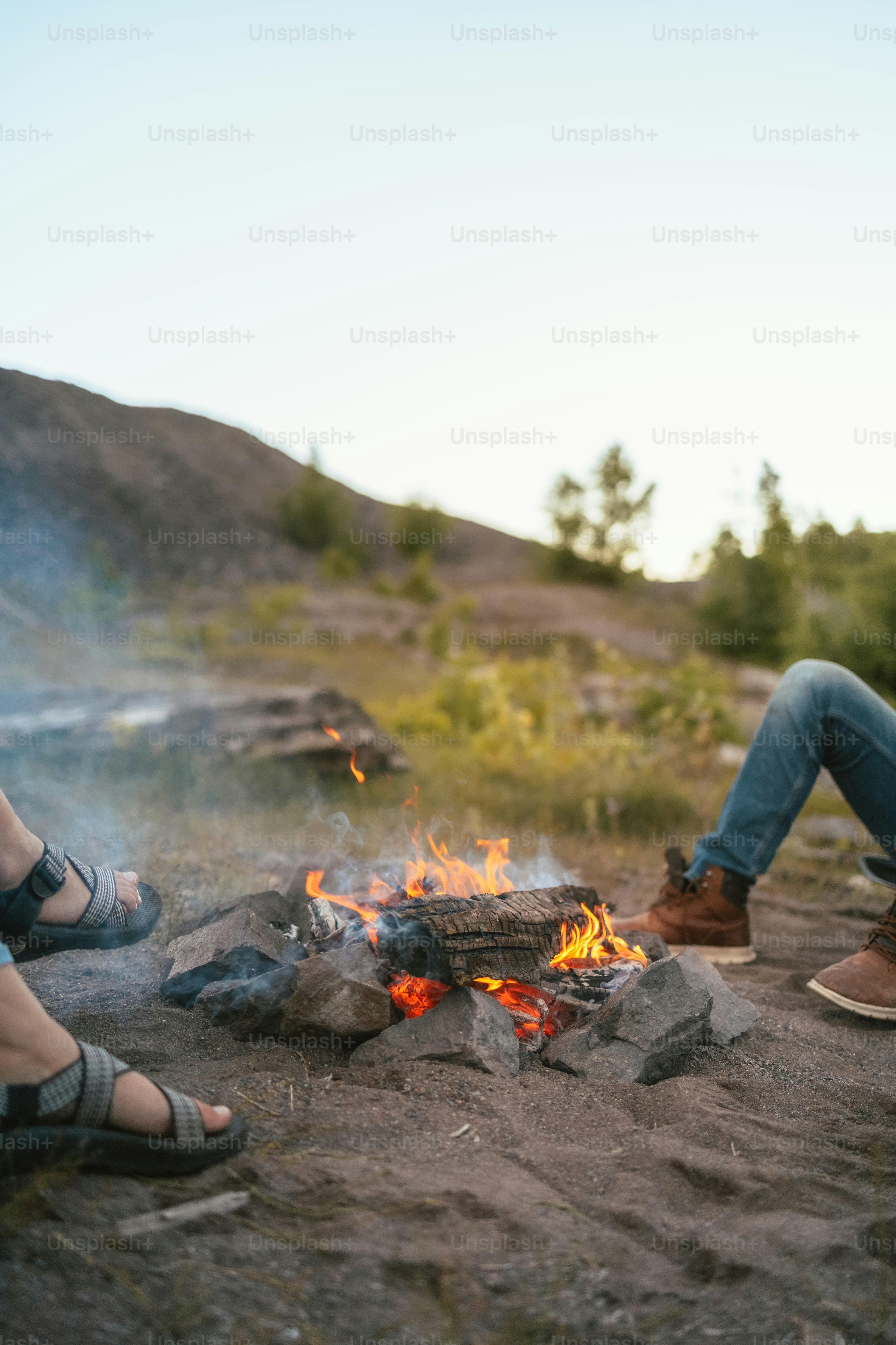 Ein paar Leute, die neben einem Feuer sitzen