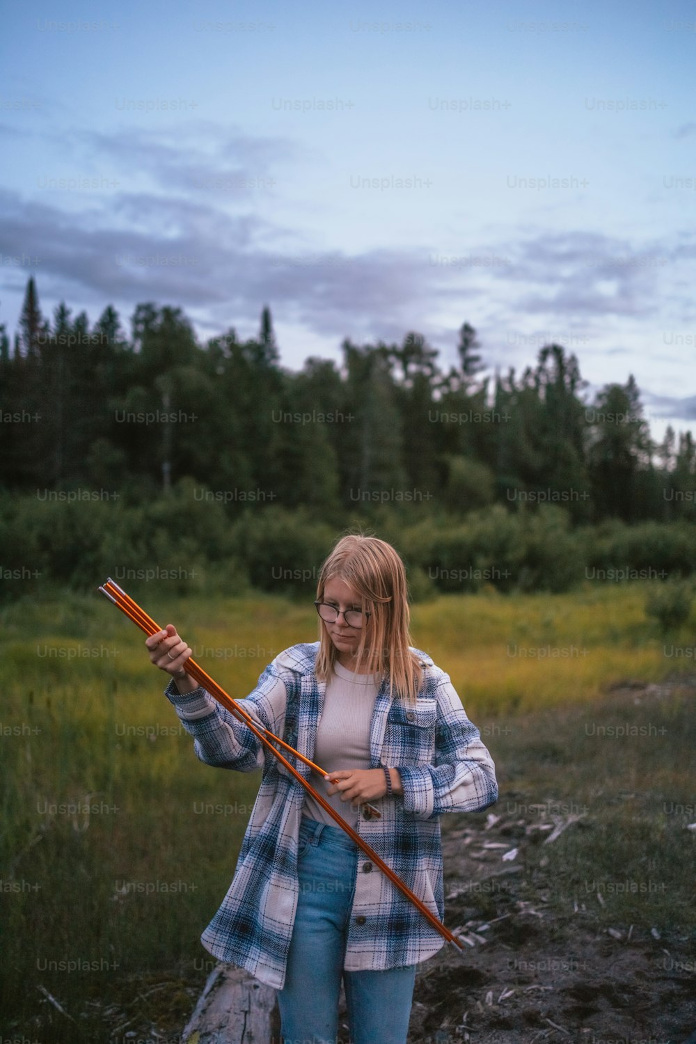 Une femme tenant un bâton dans un champ
