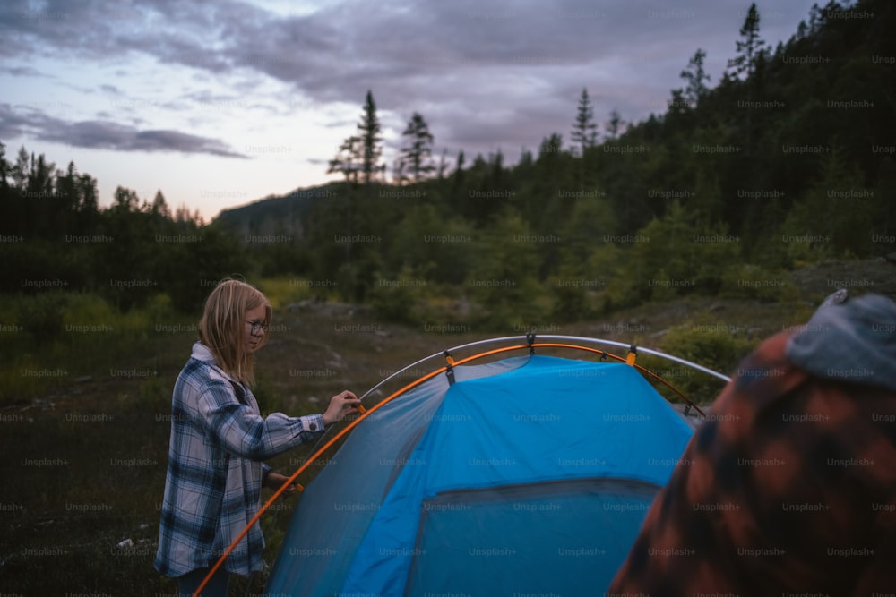 a man and a woman standing next to a tent