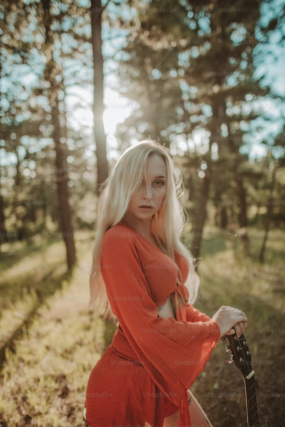 a woman in a red dress holding a guitar