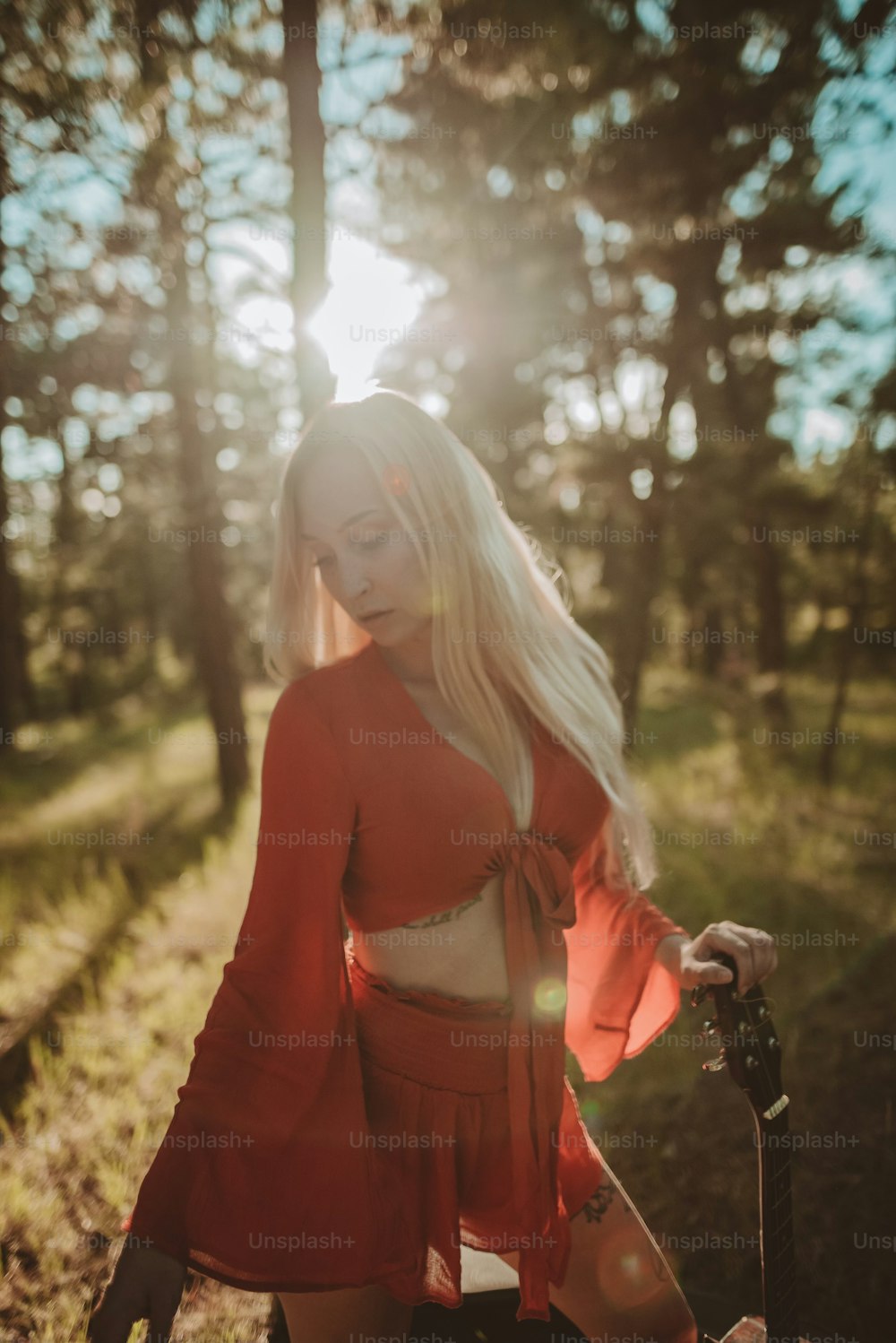 uma mulher em um vestido vermelho em pé na floresta