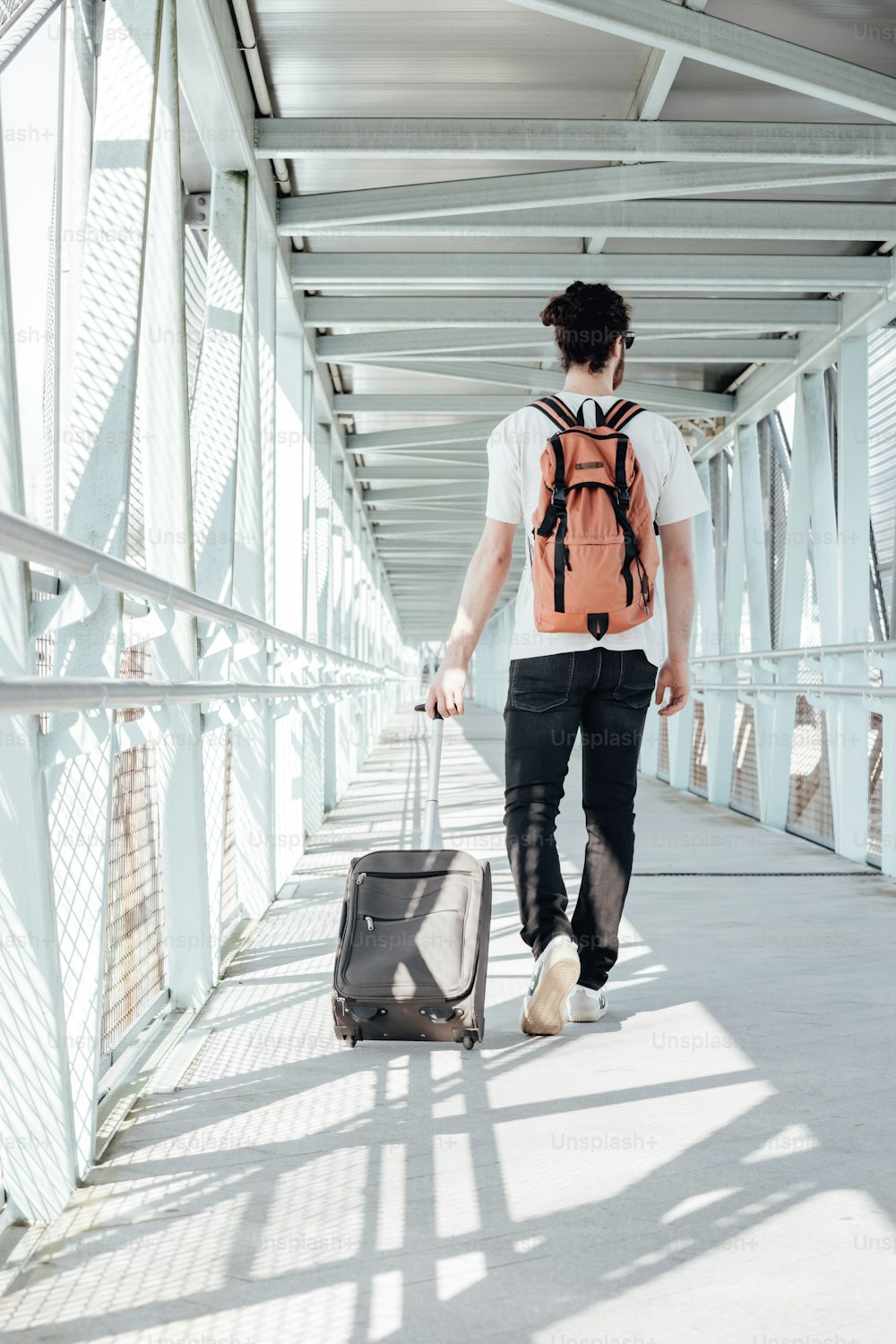 a man walking down a walkway with a suitcase
