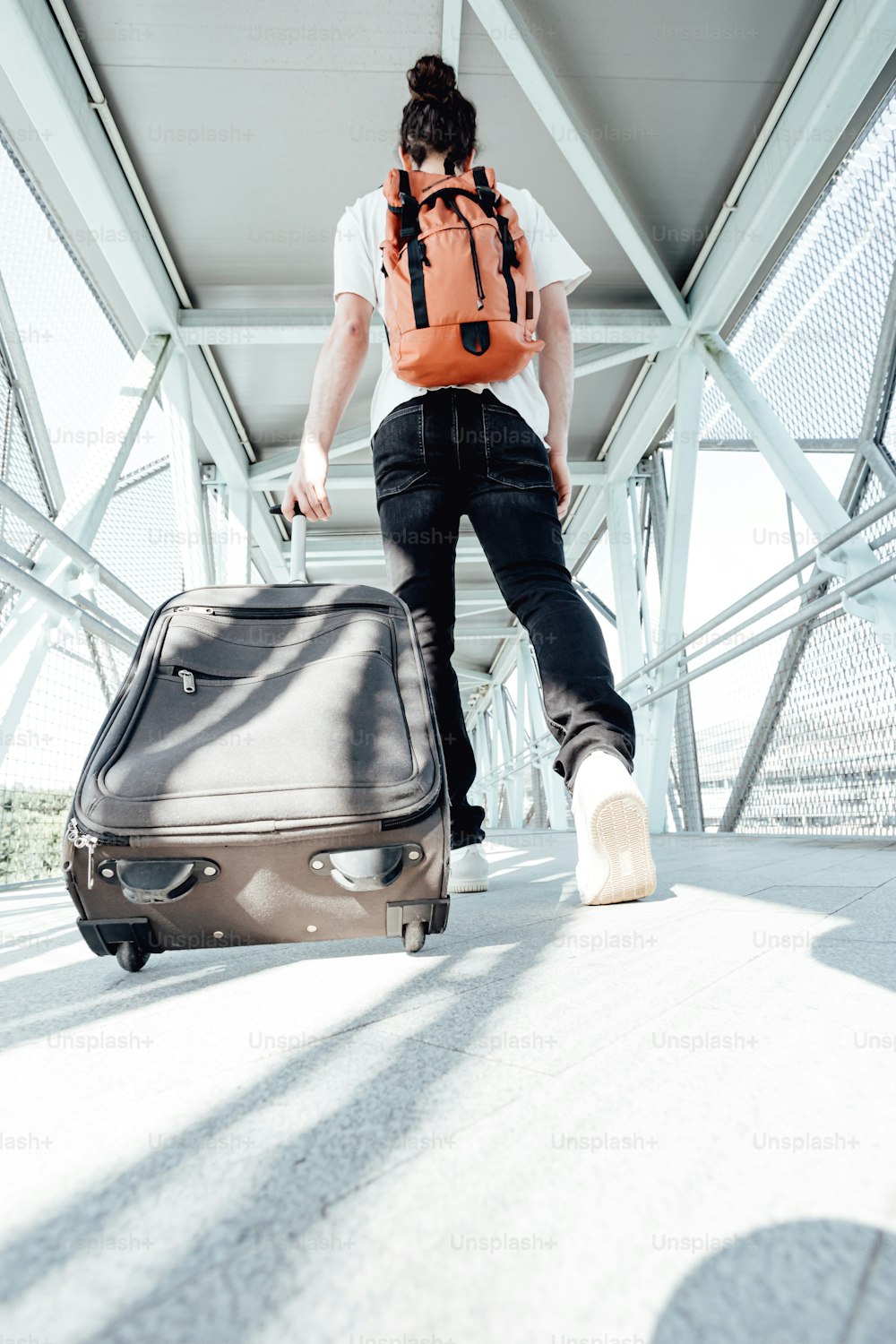 a man with a backpack pulling a suitcase