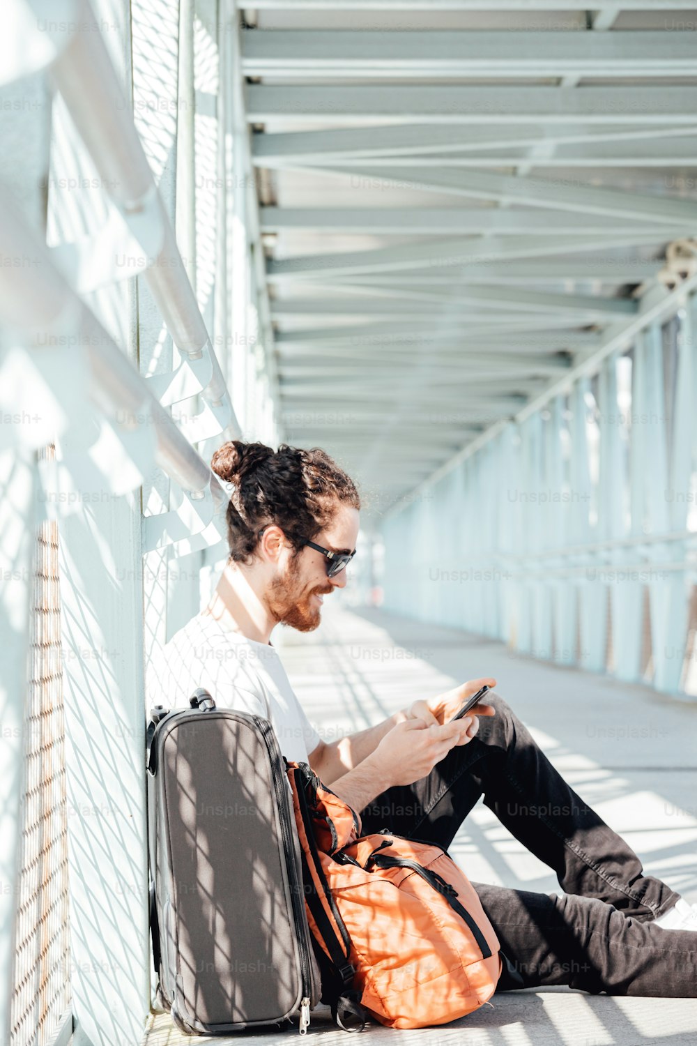 Un homme assis par terre utilisant son téléphone portable