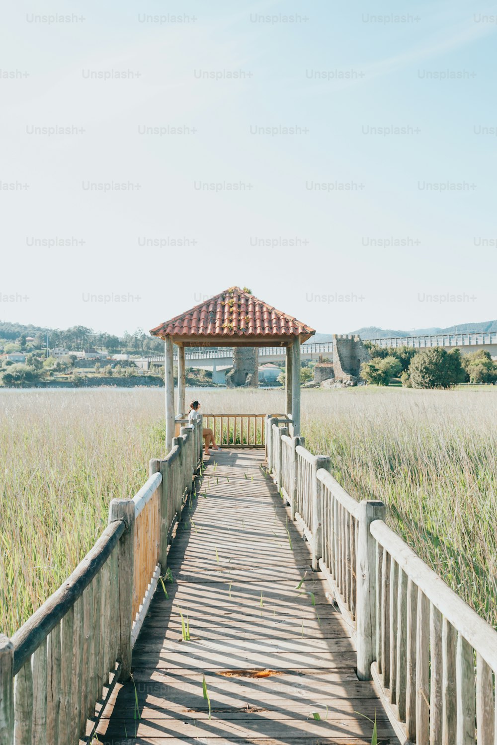 a wooden walkway leading to a gazebo in a field