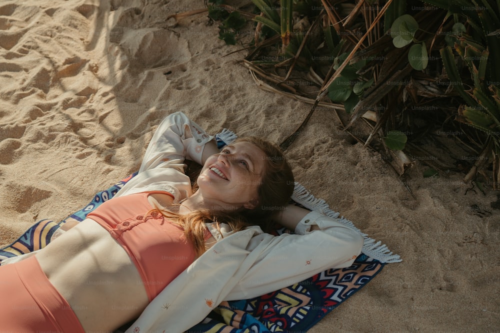 una donna che si posa su un asciugamano sulla spiaggia