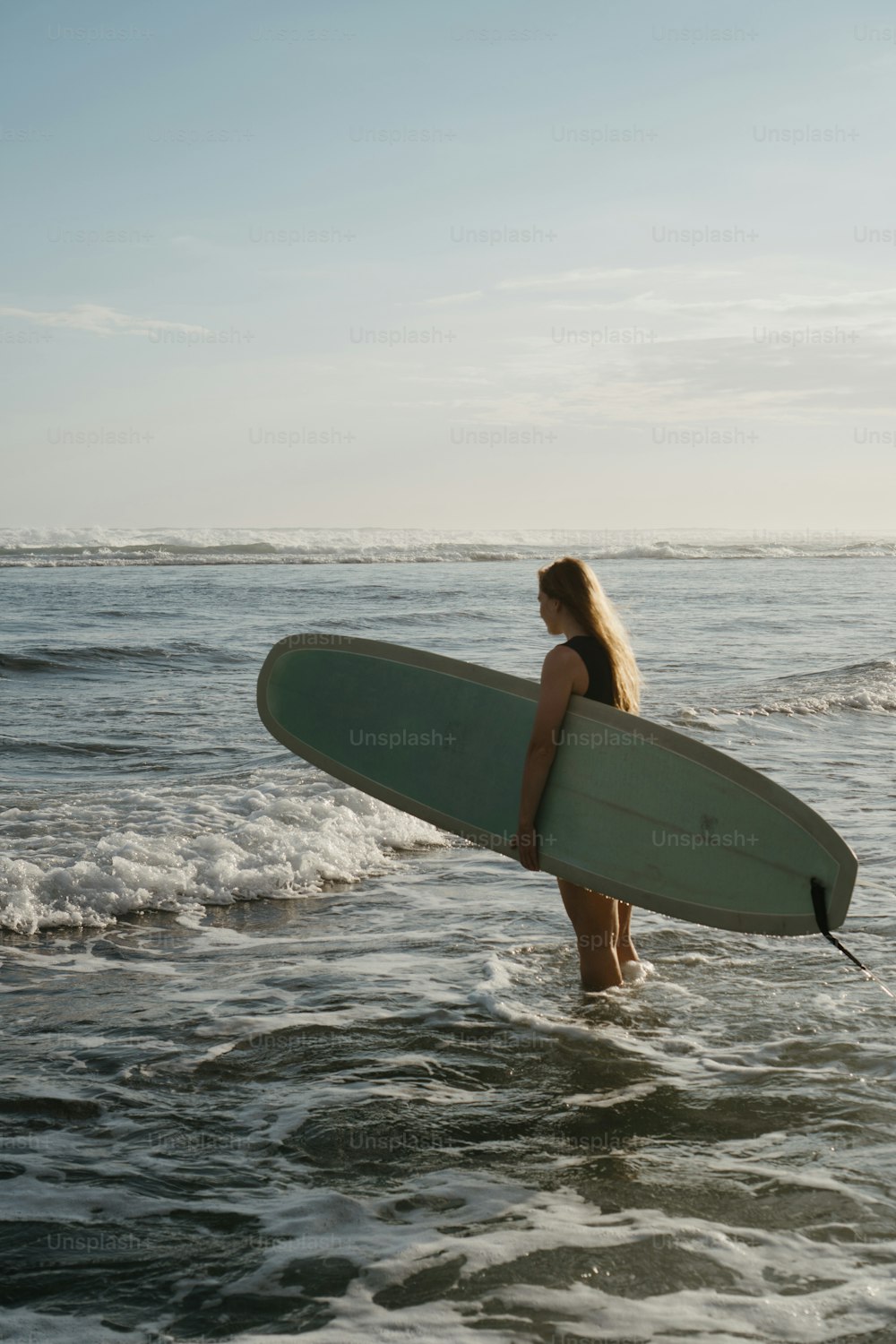 a woman holding a surfboard in the ocean