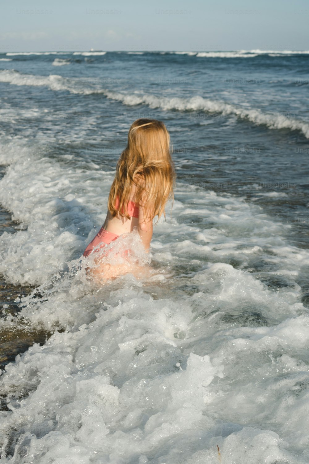 una donna che gioca nell'acqua in spiaggia