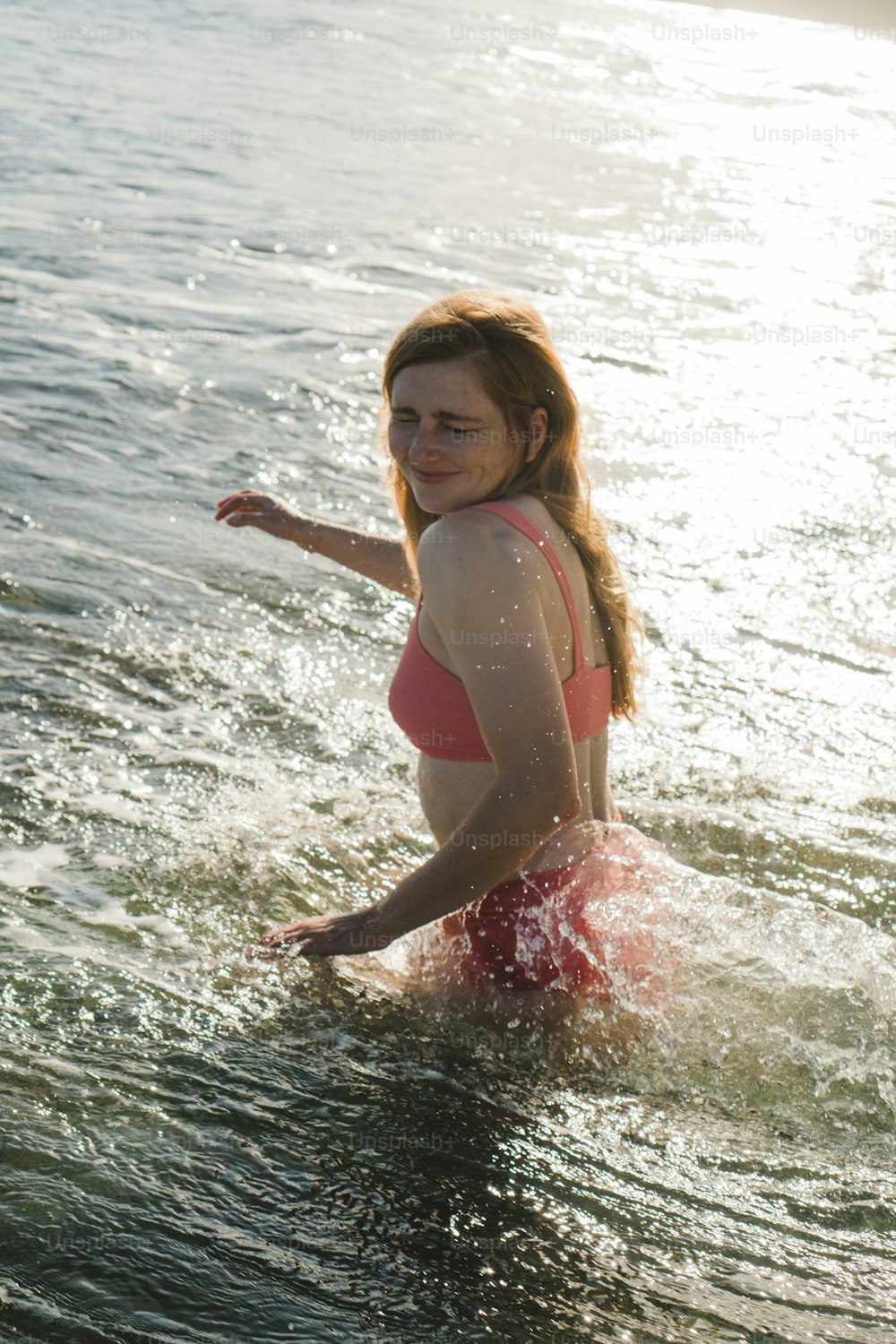 a woman in a bathing suit wading in the water