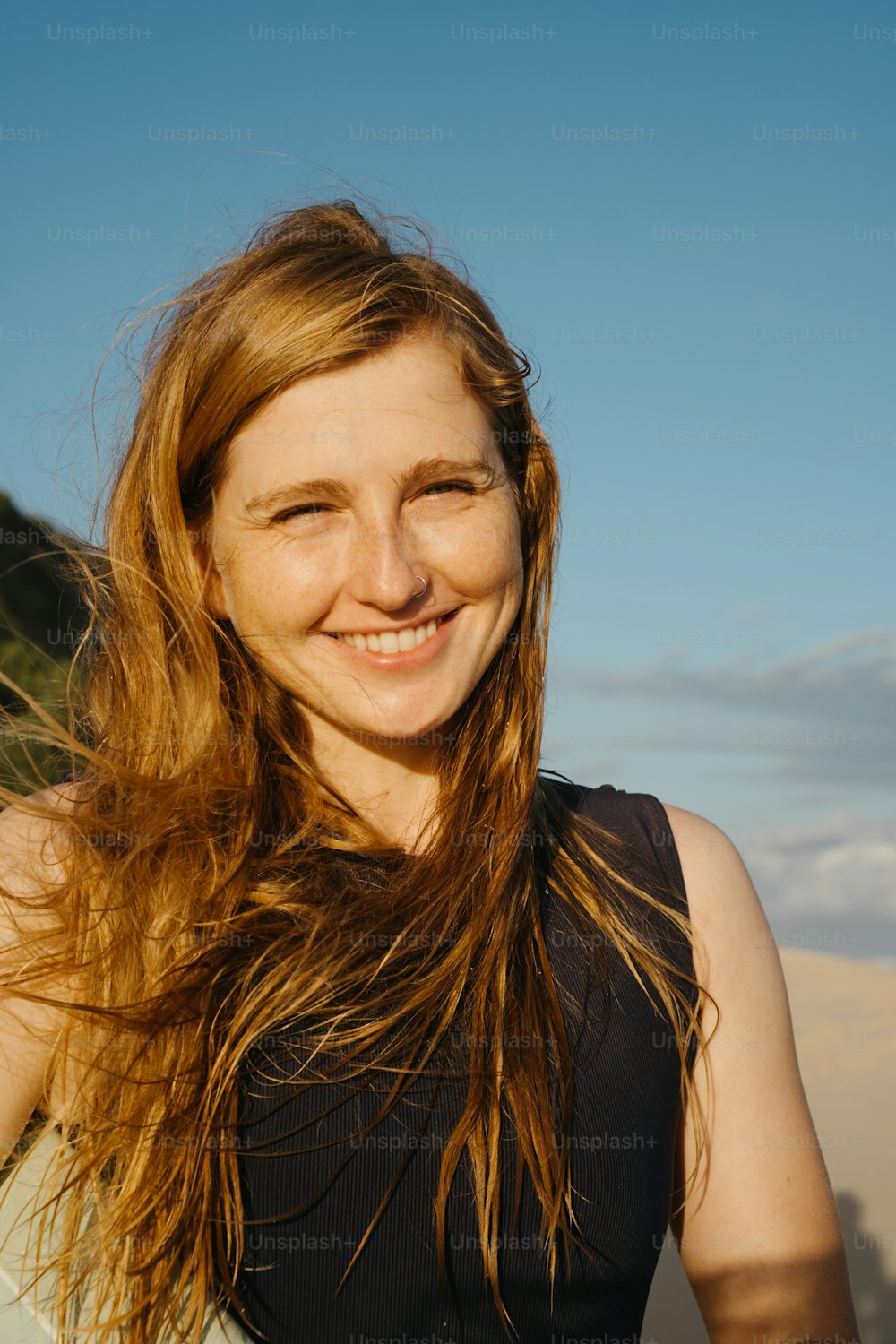 a woman with long hair standing in the sand