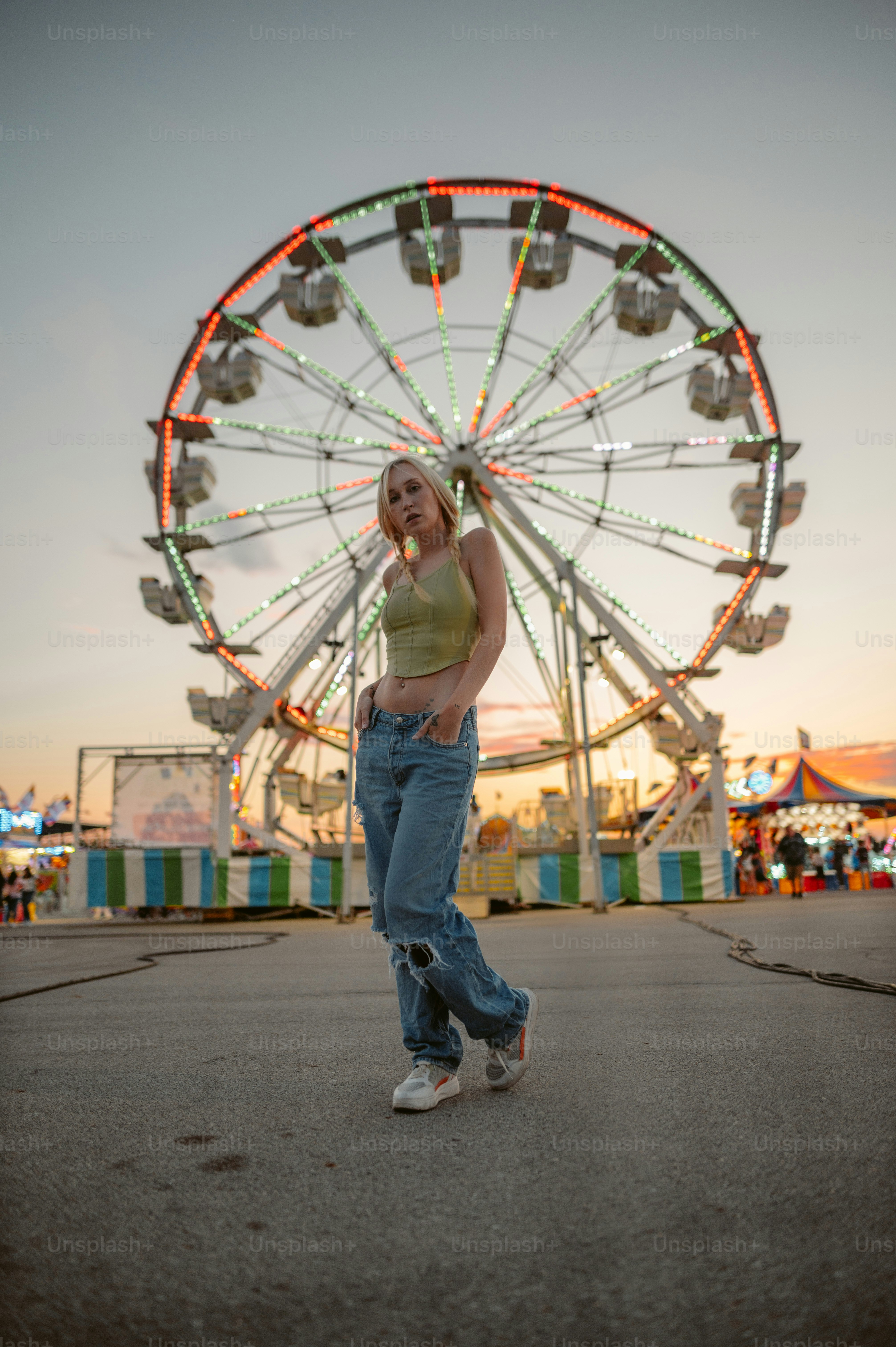 A woman standing in front of a ferris wheel photo – Eye catching Image ...