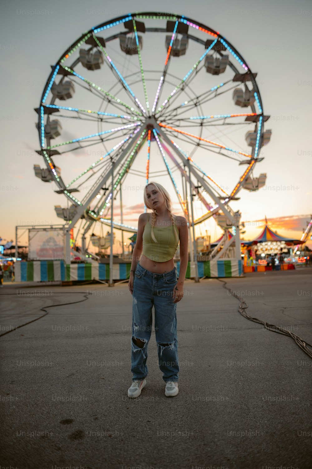 a woman standing in front of a ferris wheel