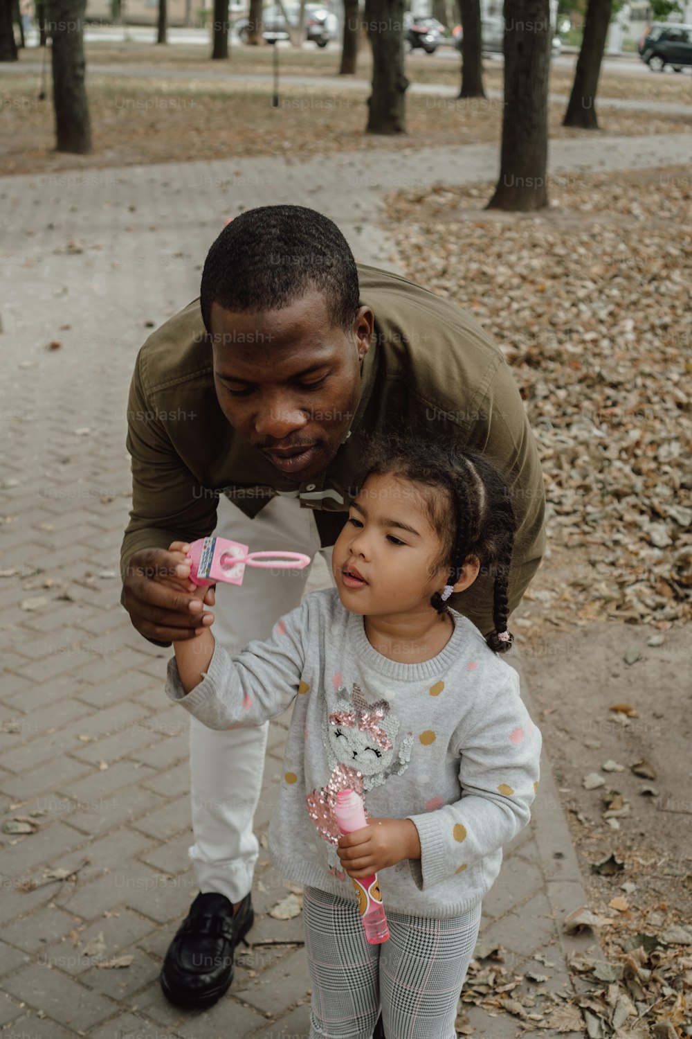 a man holding a toothbrush to a little girl