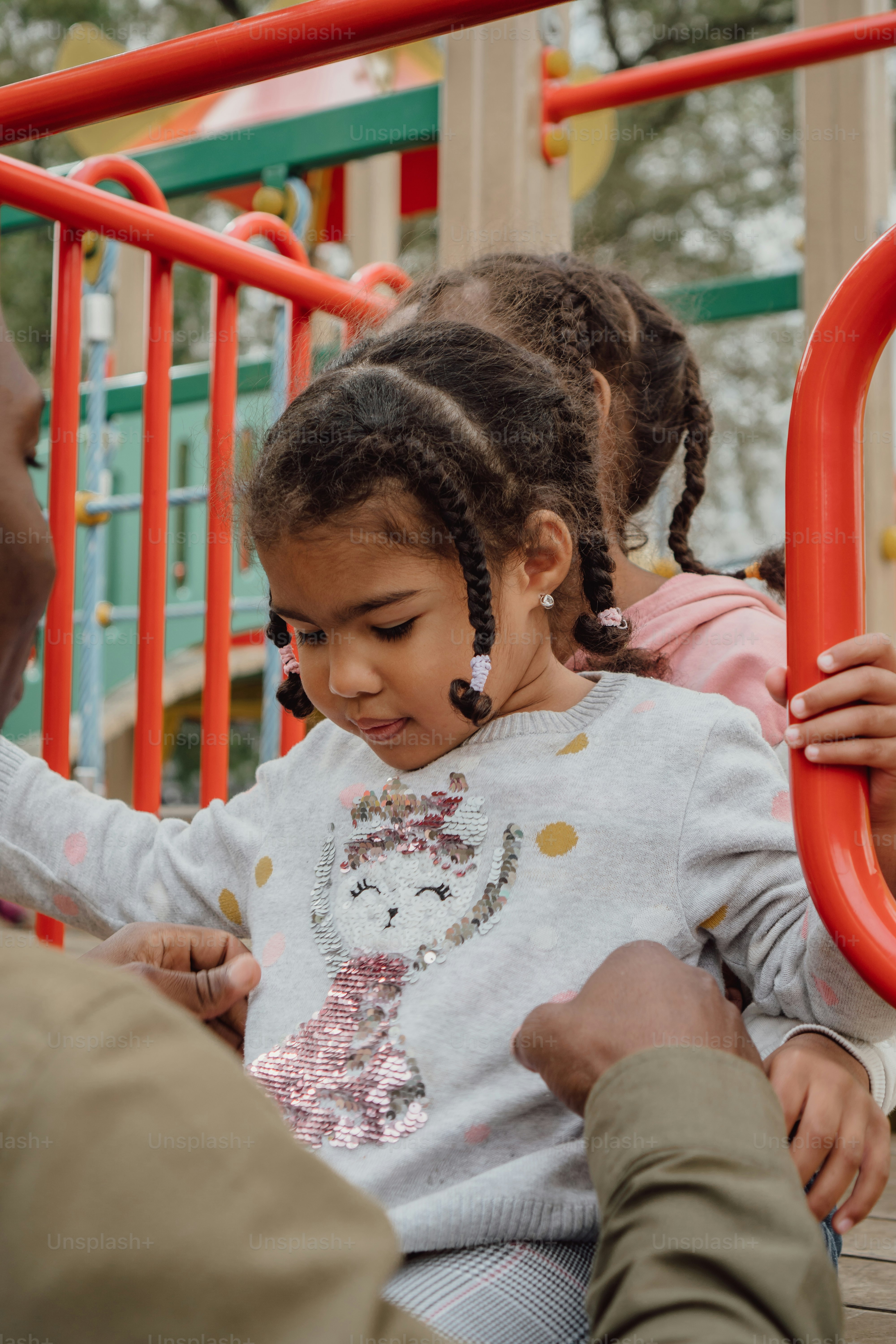Ein kleines Mädchen sitzt auf einer Spielplatzschaukel
