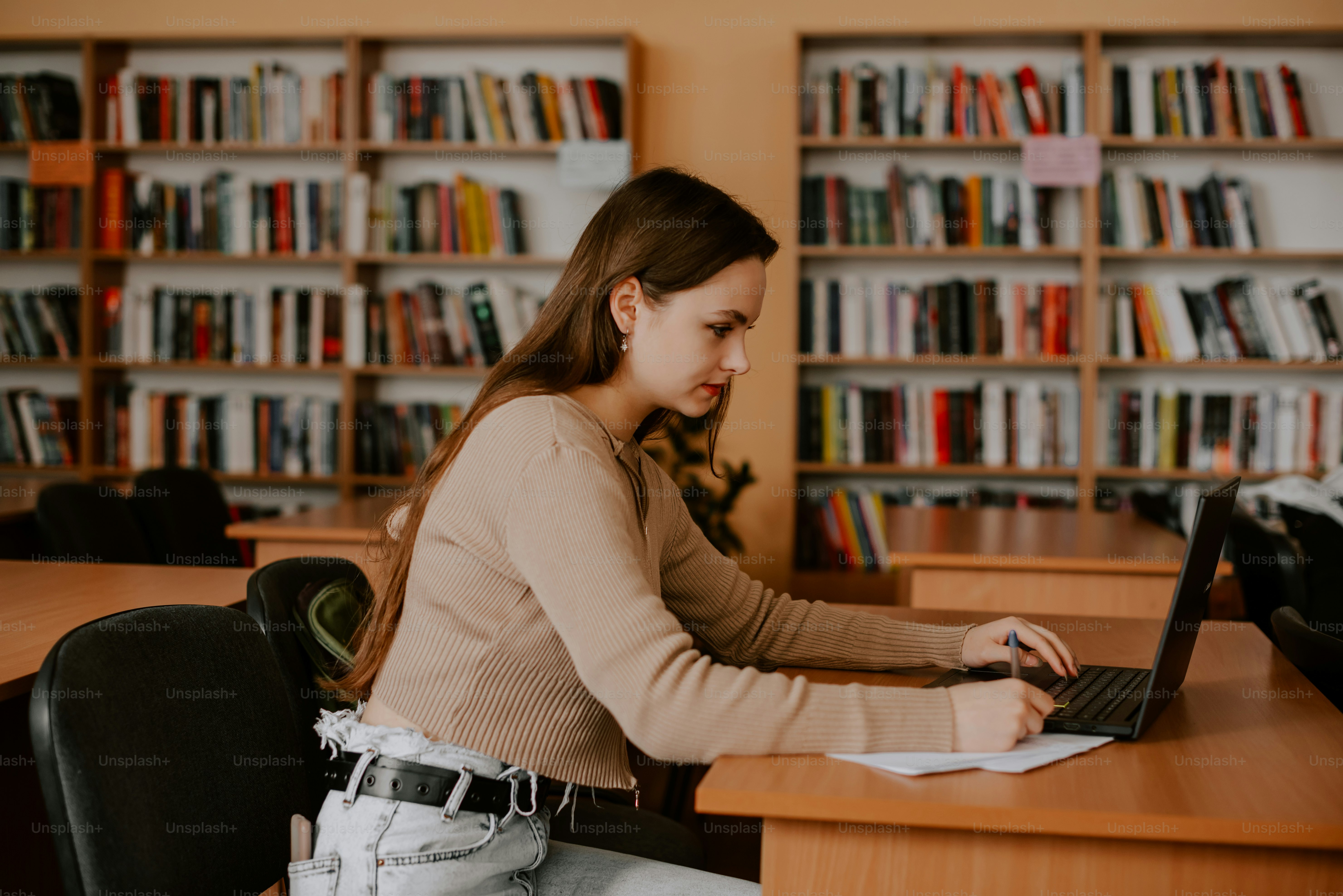 Una mujer sentada en un escritorio usando una computadora portátil