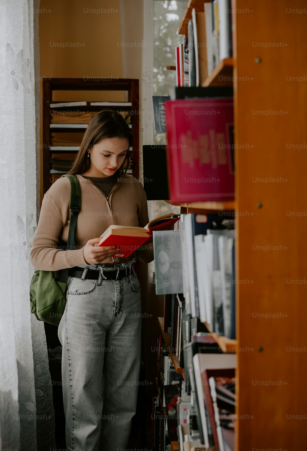 Une femme debout devant une étagère à livres
