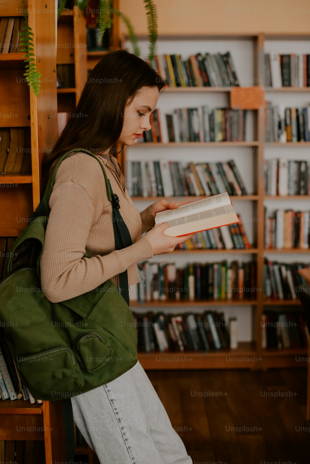 a woman reading a book in a library