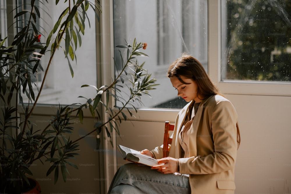 a woman sitting in a chair reading a book