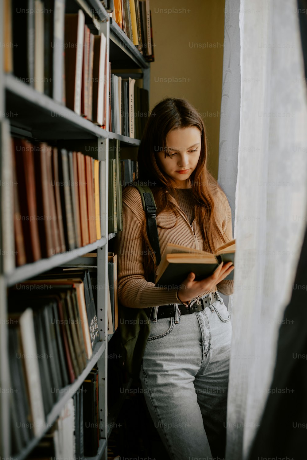 Une femme lit un livre dans une bibliothèque