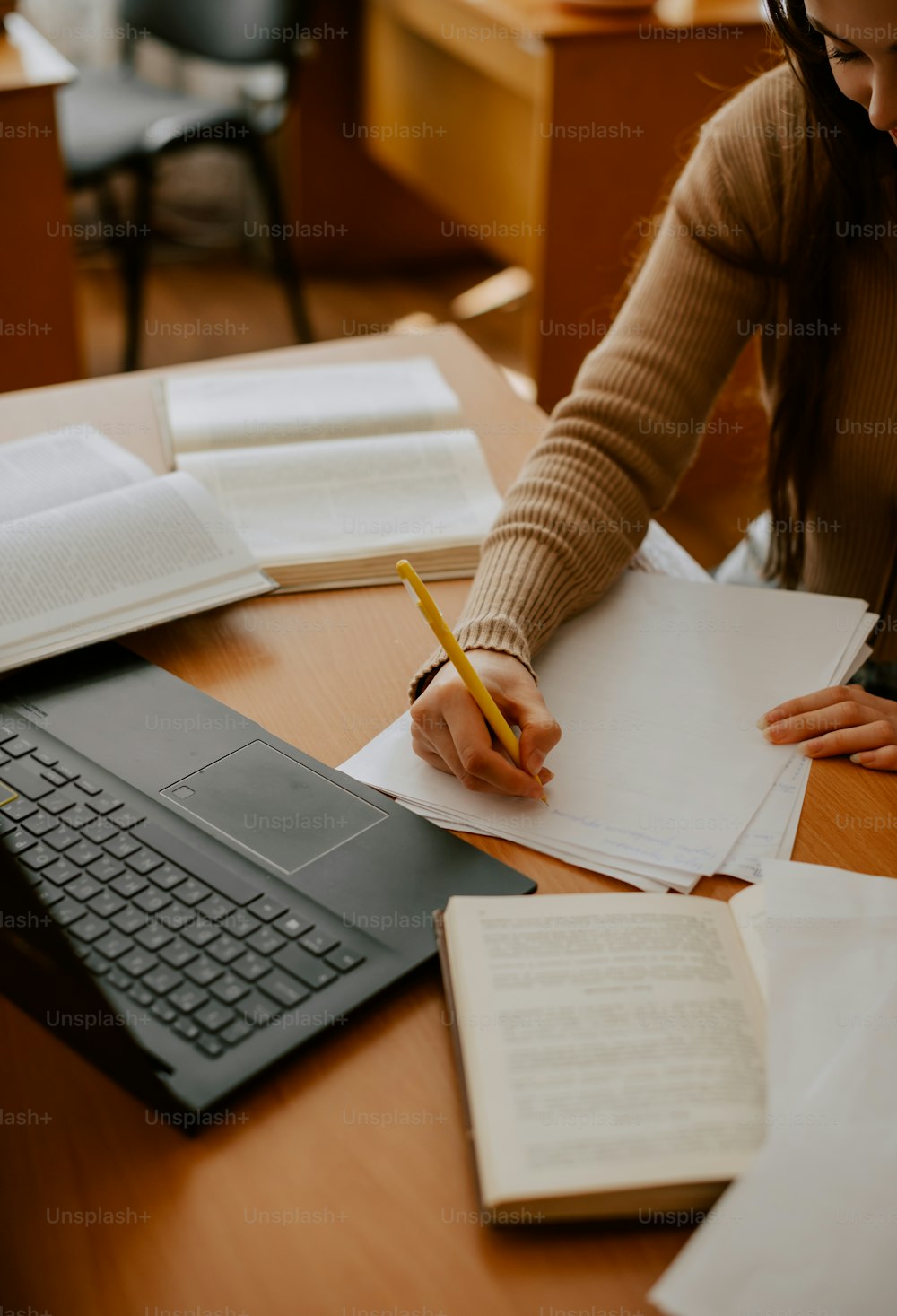 a woman sitting at a desk writing on a piece of paper