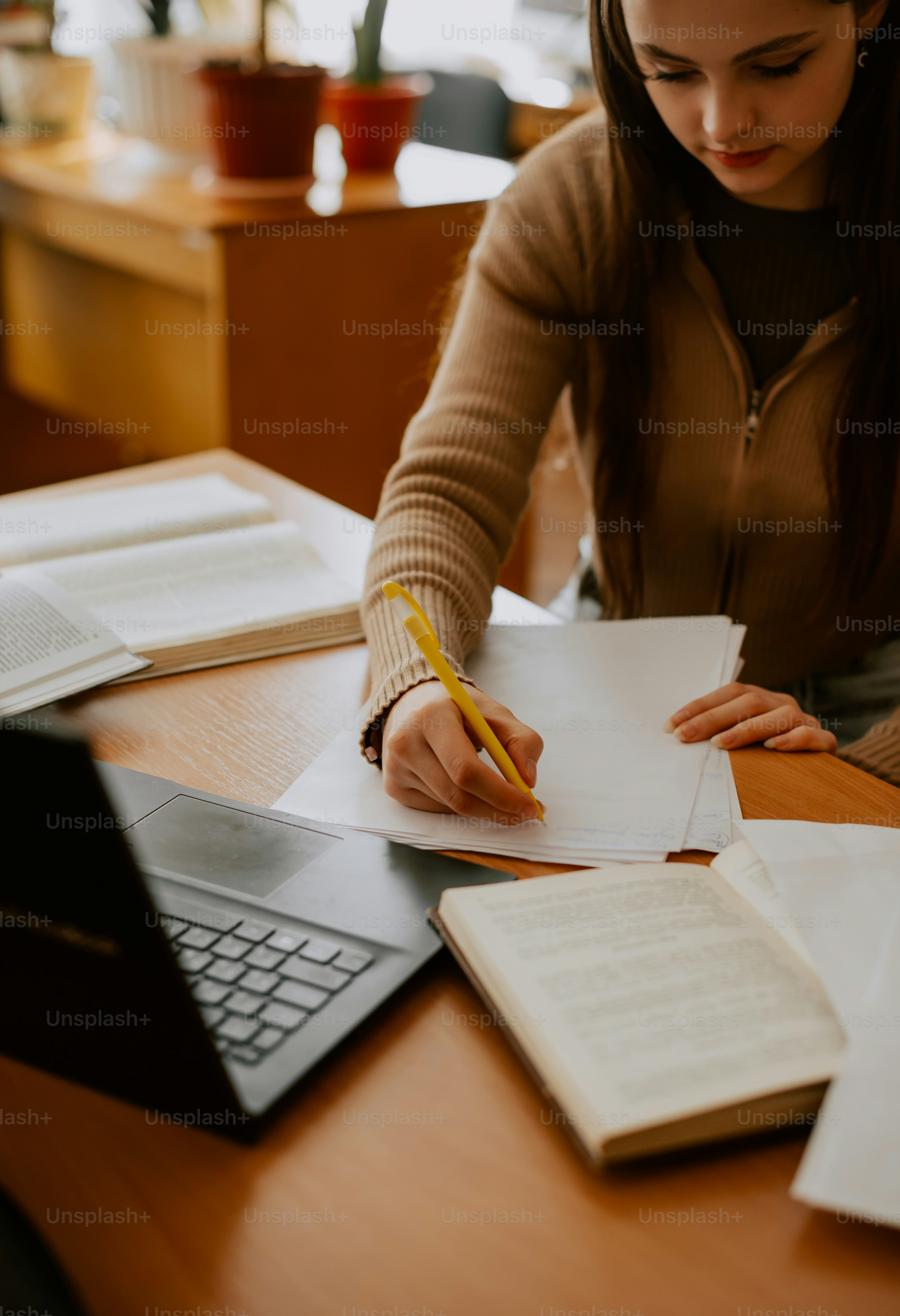 a woman sitting at a desk writing on a piece of paper